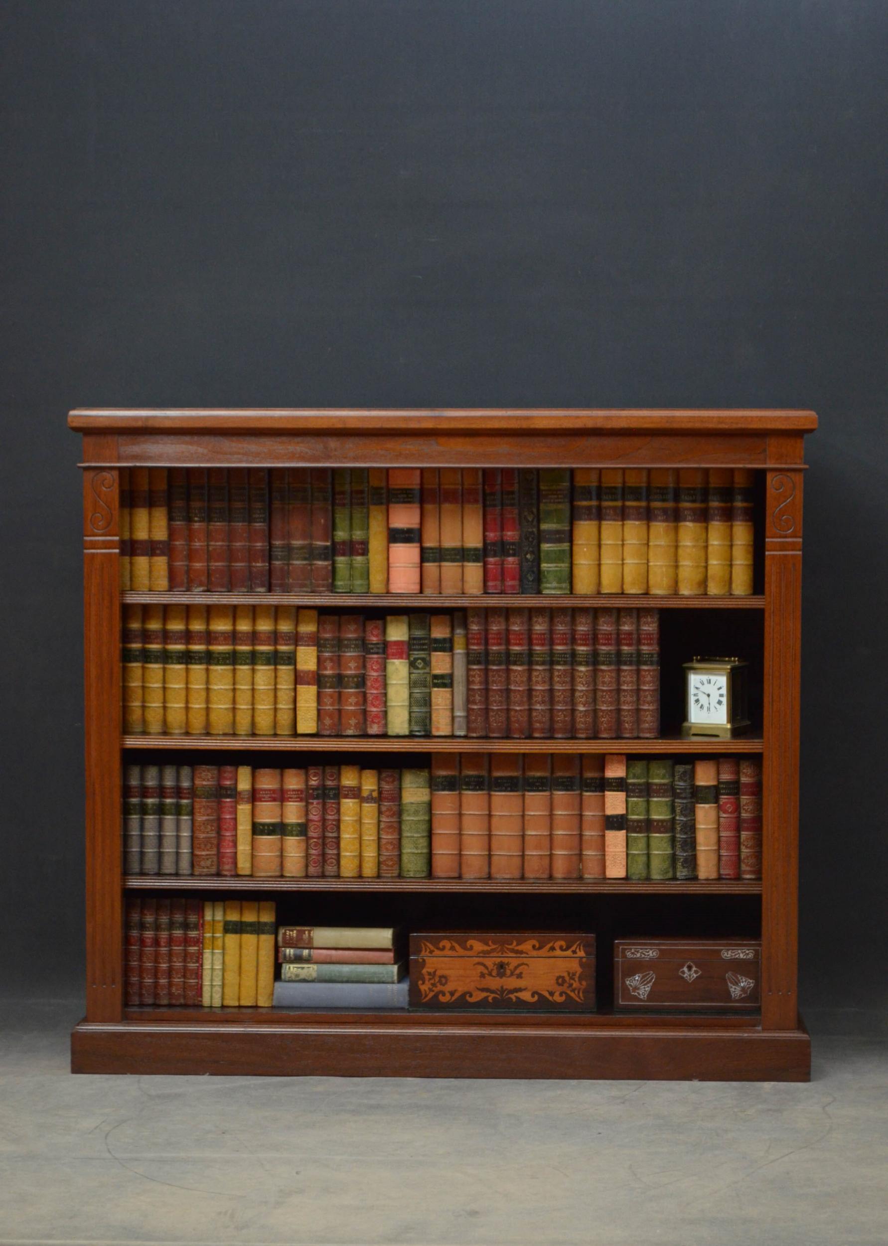 Sn4643 simple Victorian bookcase in walnut, having figured top with moulded edge above three height adjustable shelves flanked by scroll decoration and reeded pilasters, all standing on moulded plinth base. This antique bookcase has been