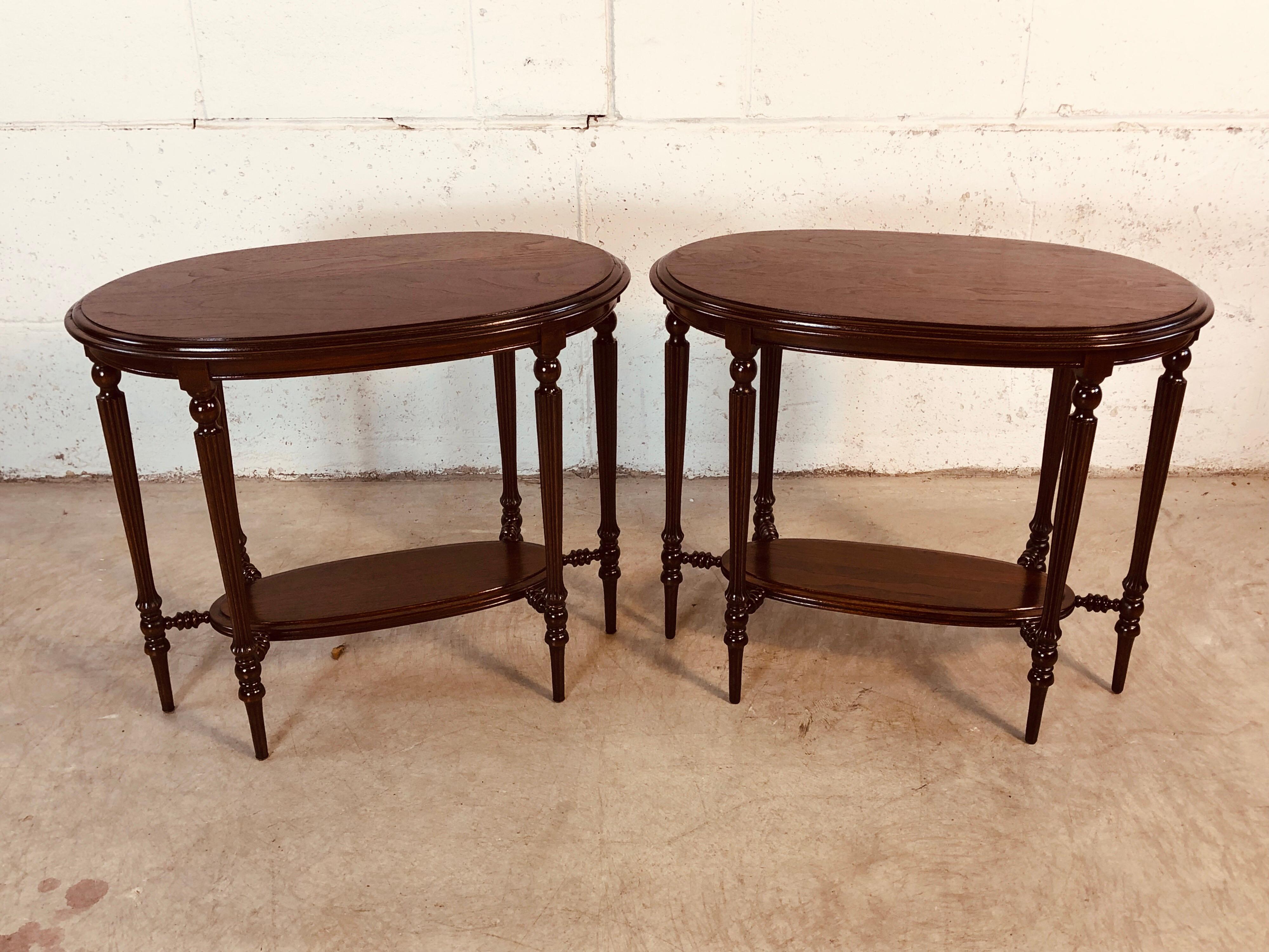 Late Victorian period pair of oval walnut wood side tables. The tables have a second shelf with turned supports. The legs are carved and end with delicate feet. The tables have been refinished and restored. There is no maker’s mark.