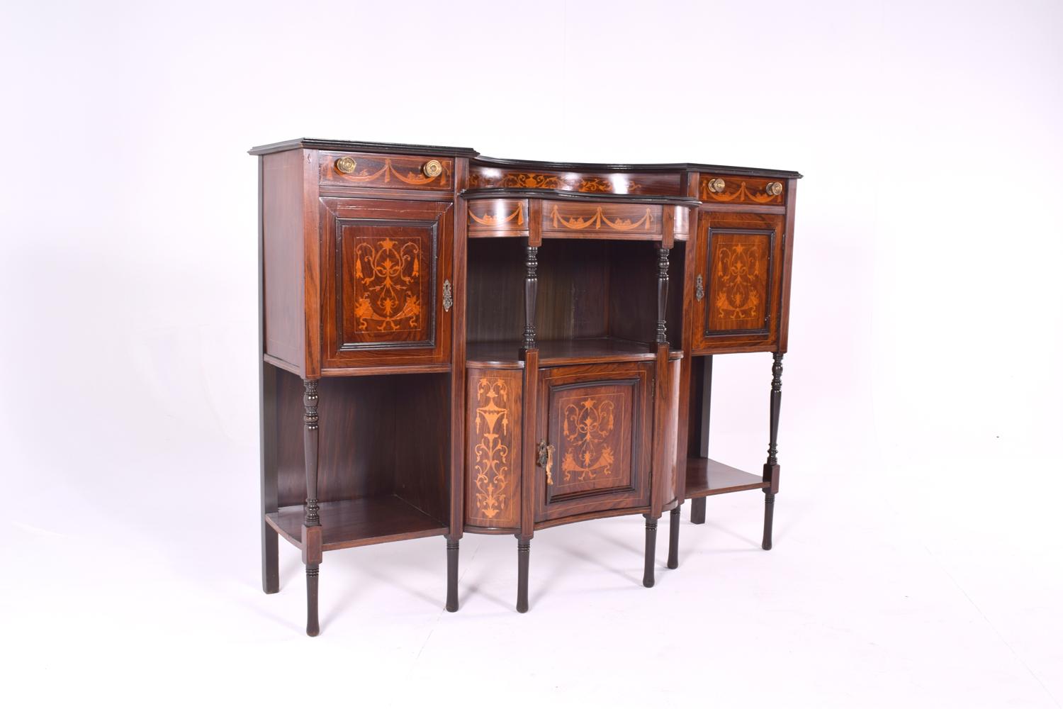 English rosewood and inlaid breakfront outline with an open space and enclosed by central panel door decorated, to either side by a panel door also decorated.
This Victorian piece has a beautiful and delicate inlaid work, decorations that are not