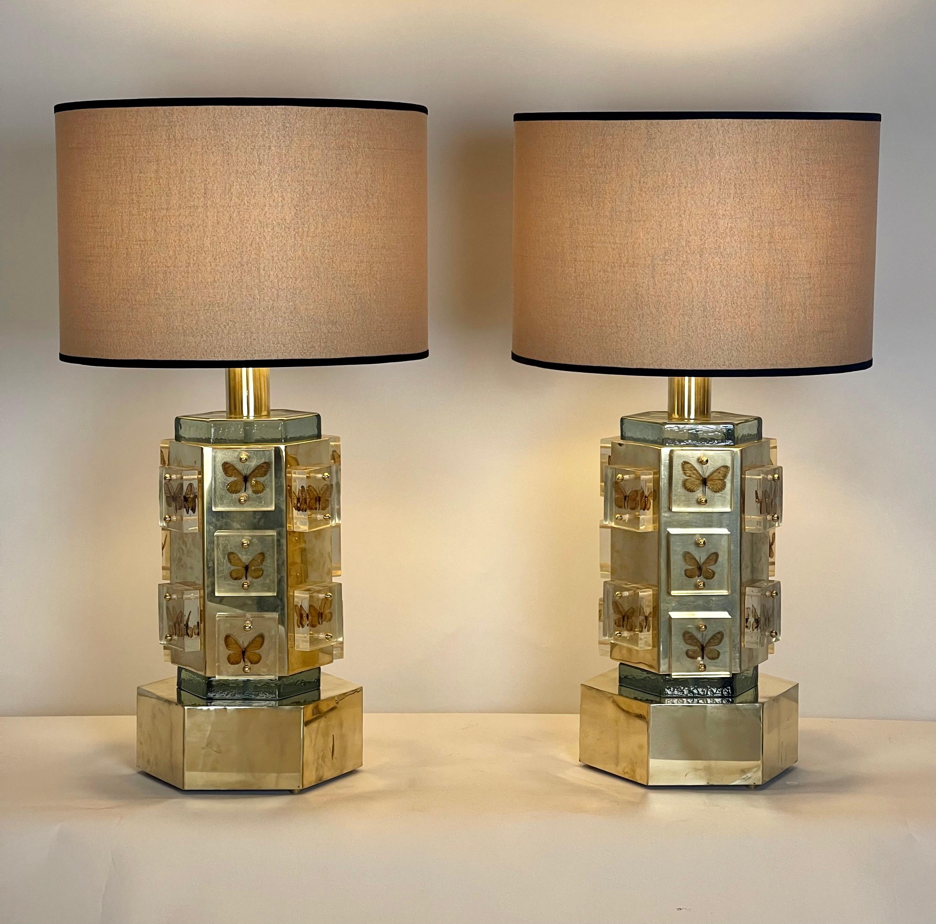 Each table lamp has an hexagonal brass body with two hexagonal green murano glass plates and 15 butterflies encased in plexiglass squared blocks.
Beige cottone shades, size: 45 Diameter x 30 Height cm. included.
Total lamp height with shade: 82