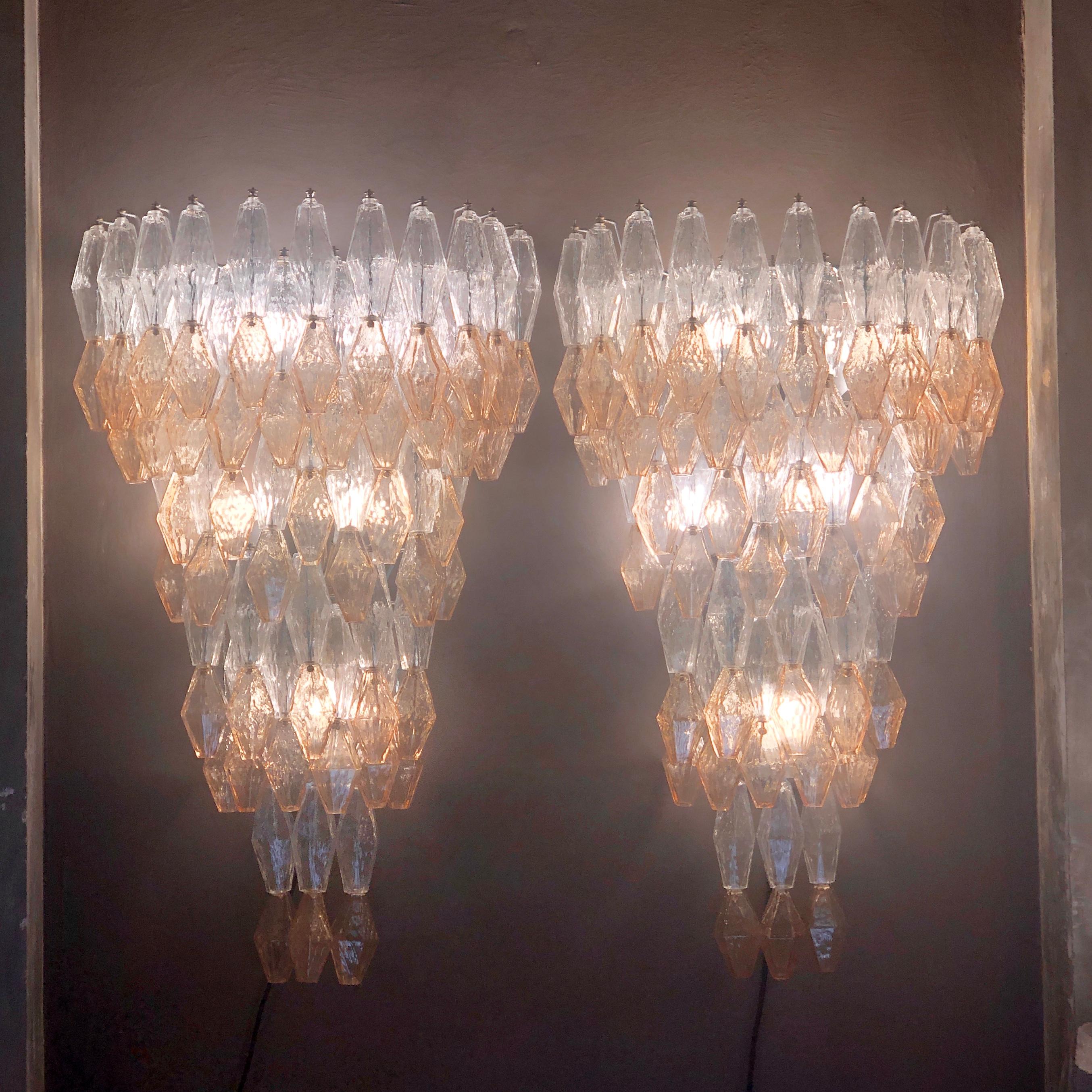 Paire d'appliques en verre de Murano (réalisé avec la technique Balloton) de très grands polyèdres transparents et ambrés. 4 ampoules E27 + 1 E14 LB
Les polyèdres ont été conçus par l'architecte italien : Carlo Scarpa.
