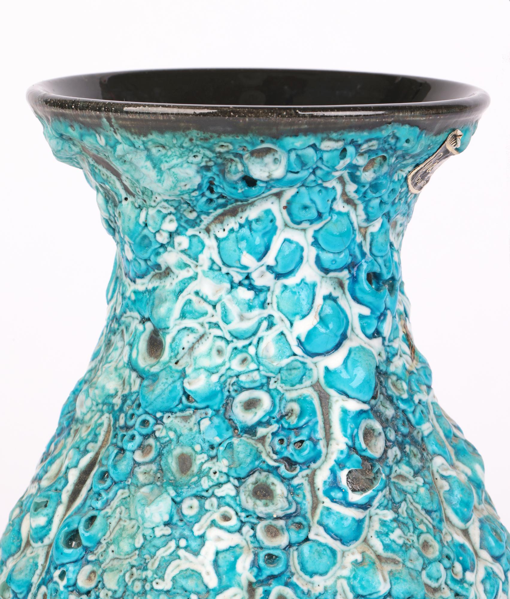 A stylish French mid-century art pottery vase decorated with turquoise lava glazes and produced by l'Atelier du Cyclope made in Annecy. The ceramic vase is lightly potted and stands on a narrow flat round unglazed base with a round body pinched neck