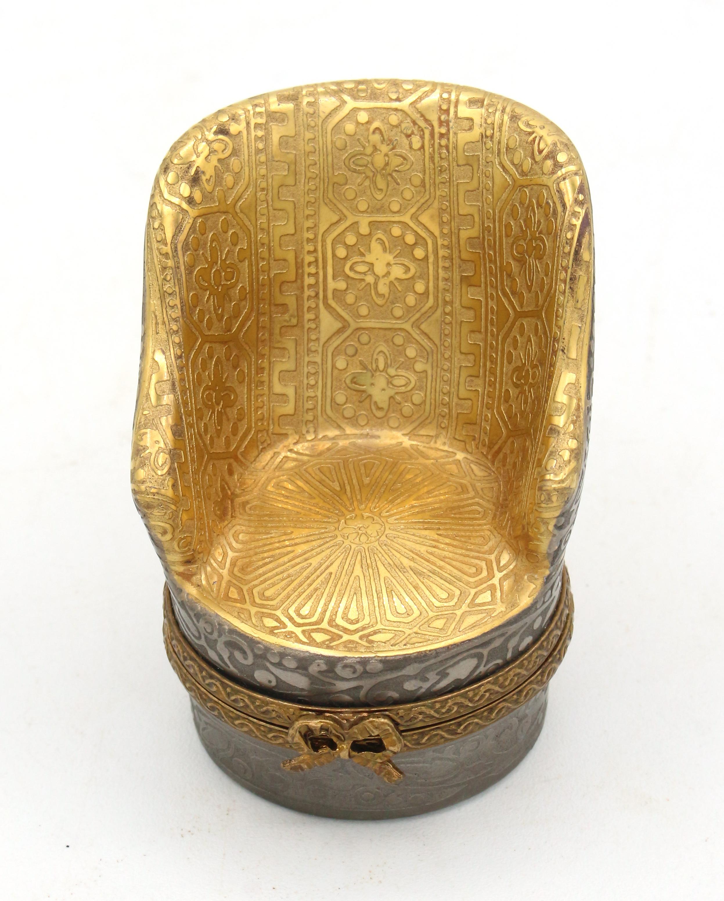 Limoges trinket or pill box in the form of a bergere chair, French later 20th century. 24k gold & silver encrused. Marked: Limoges France, Porcelaine D'Art Du Cruou, MCLS, Made in France.
1 5/8