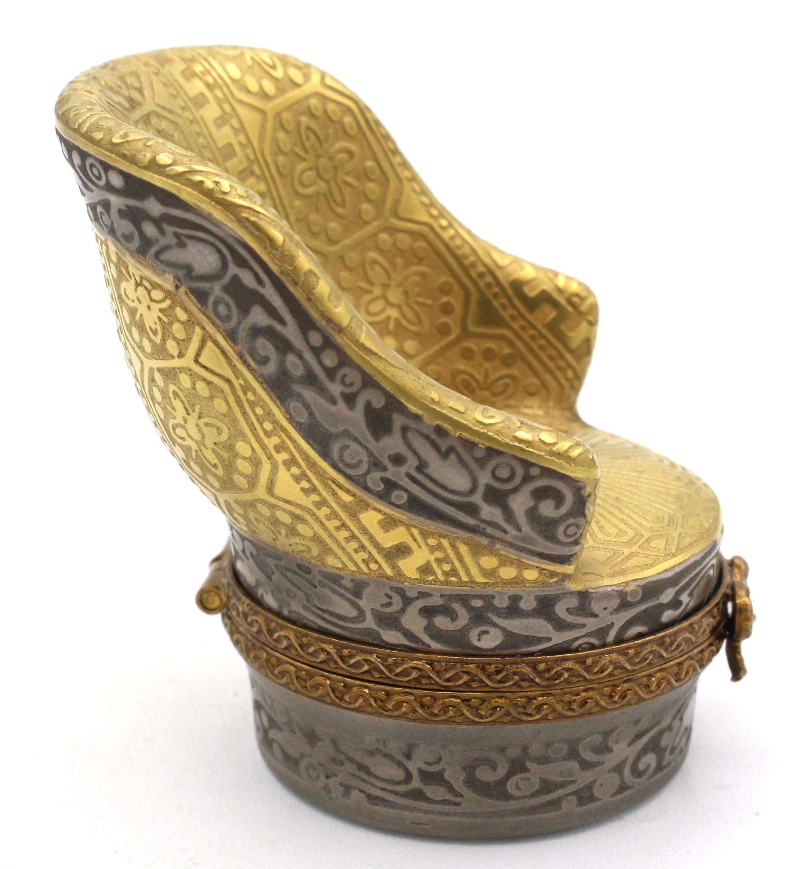 Limoges trinket or pill box in the form of a bergere chair, French later 20th century. 24k gold & silver encrused. Marked: Limoges France, Porcelaine D'Art Du Cruou, MCLS, Made in France.
1 5/8