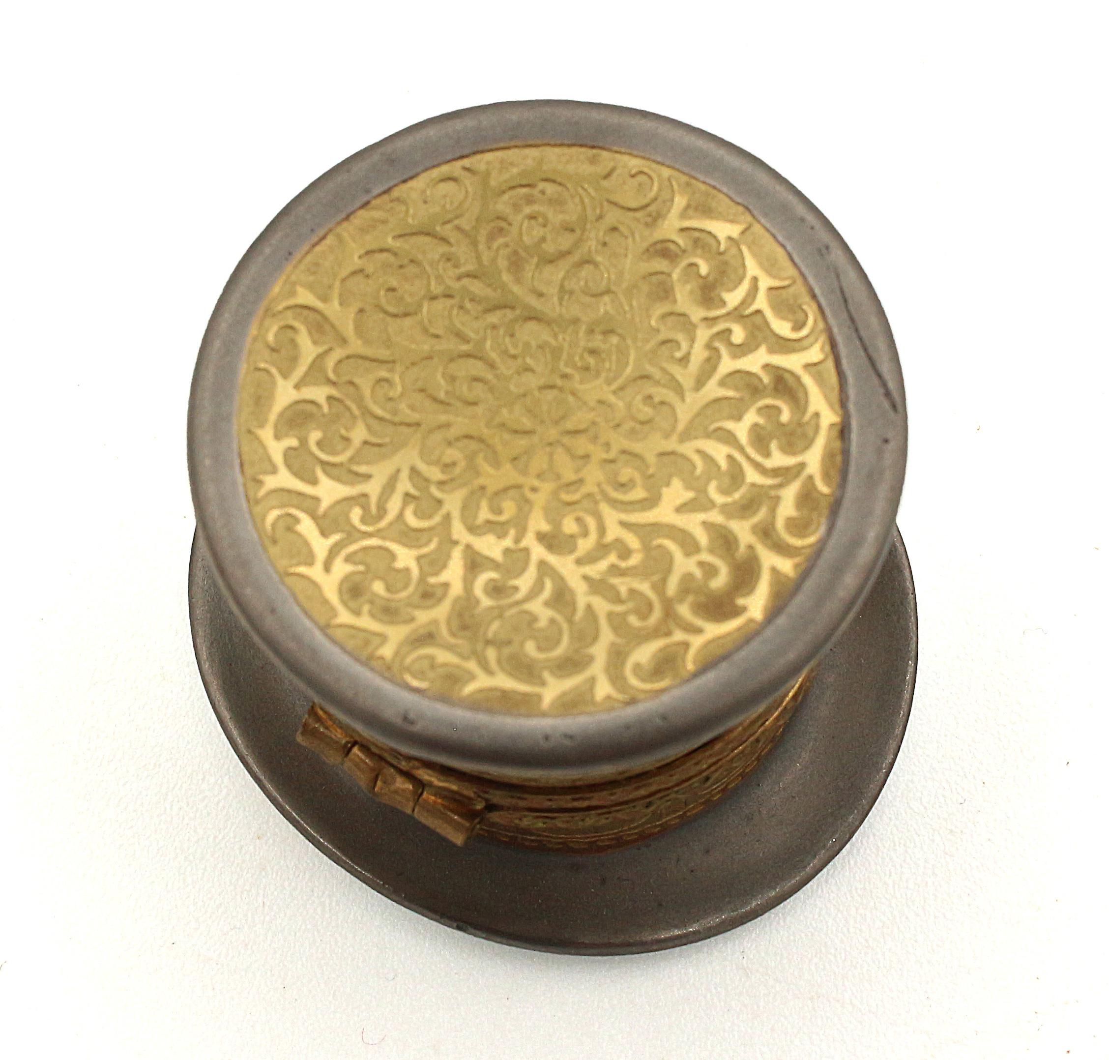 Limoges pill box in the form of a top hat, French, later 20th century. Gilded & silvered. Marked: Limoges France, Peint main, Incrustation or fin (painted by hand, fine gold inlay).
1 5/8
