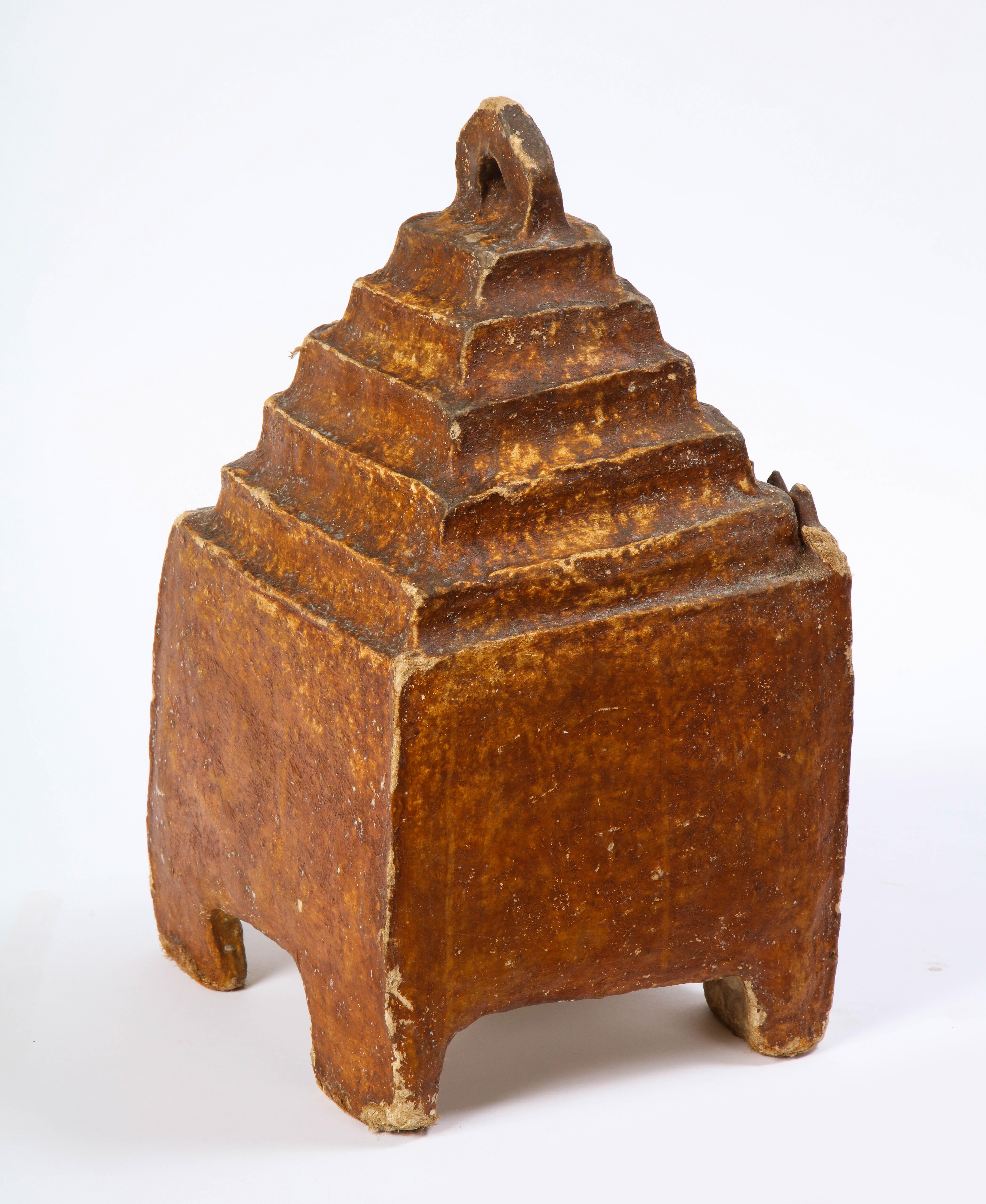 This charming Latin American composition birdhouse is painted a warm bronze color with painted decoration and mirrored inset throughout. The birdhouse is of stepped pyramid-form with a hanging finial and sits on four legs. The small opening is a