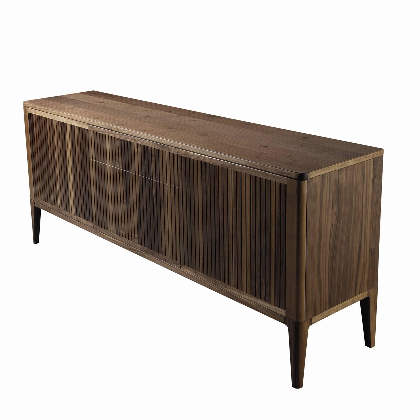 Standing tall on four tapered legs, this impressive sideboard displays a clean approach to contemporary, functional design. Made of the highest quality walnut, the imposing frame features two side doors and a central unit with three drawers whose