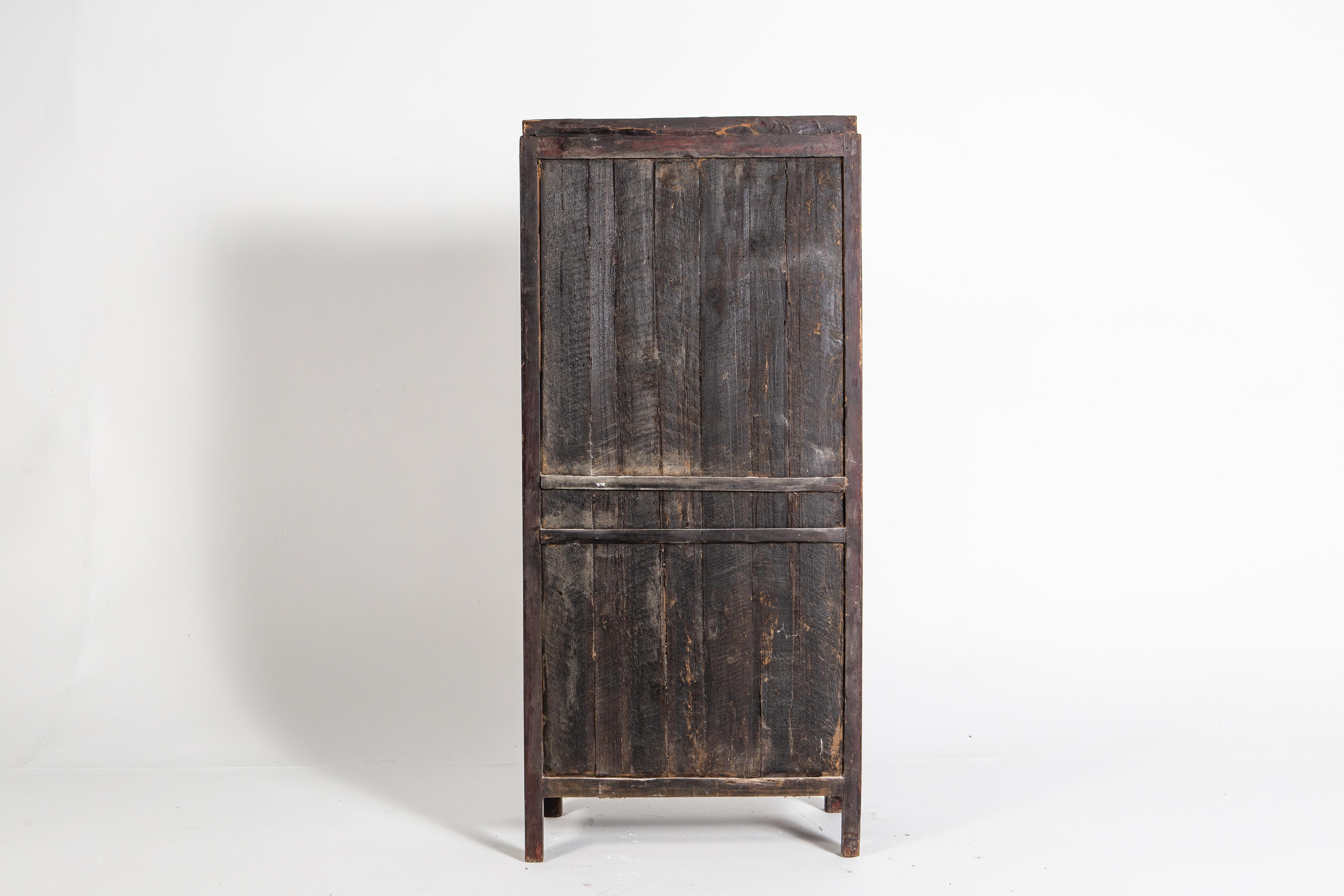 This lattice door cabinet came from Jiangsu, China and dates to the late 1900s. It was originally used to provide extra storage in the dining or sleeping areas of a home. It is made from Fir wood, covered in oxblood lacquer. Oxblood is one of the