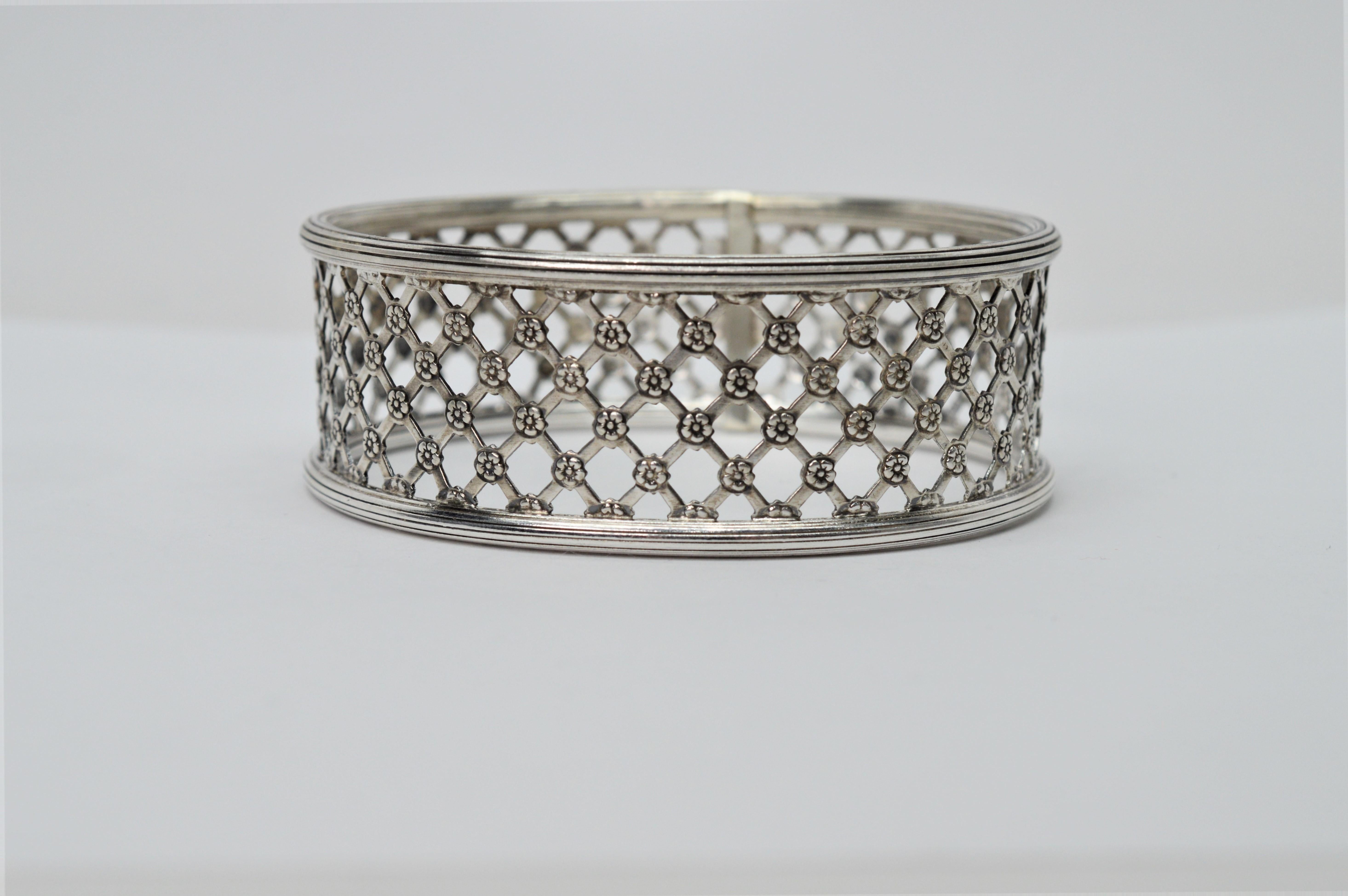An open lattice pattern appointed with floral accents creates a unique lacey design to this substantial sterling silver artisan bangle bracelet. Crafted of heavier gauge reclaimed sterling silver and trimmed with a rim of silver atop and bottom by