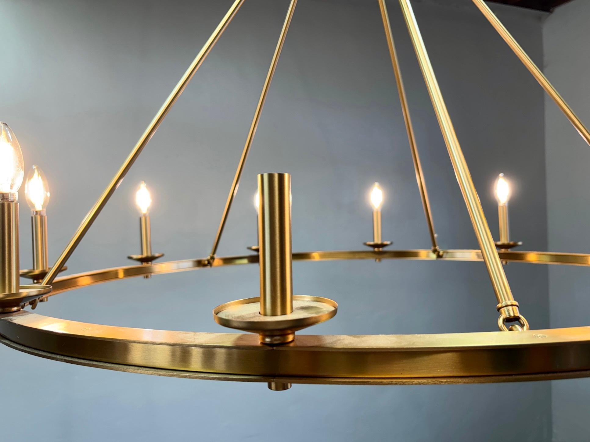 Visual Comfort Launceton Oversize Ring Chandelier. Made with 10 candelabra style light sockets. Antique wagon wheel/ring chandelier design, but made with a gorgeous antique-burnished brass finish. The fixture's large size would make it a grand
