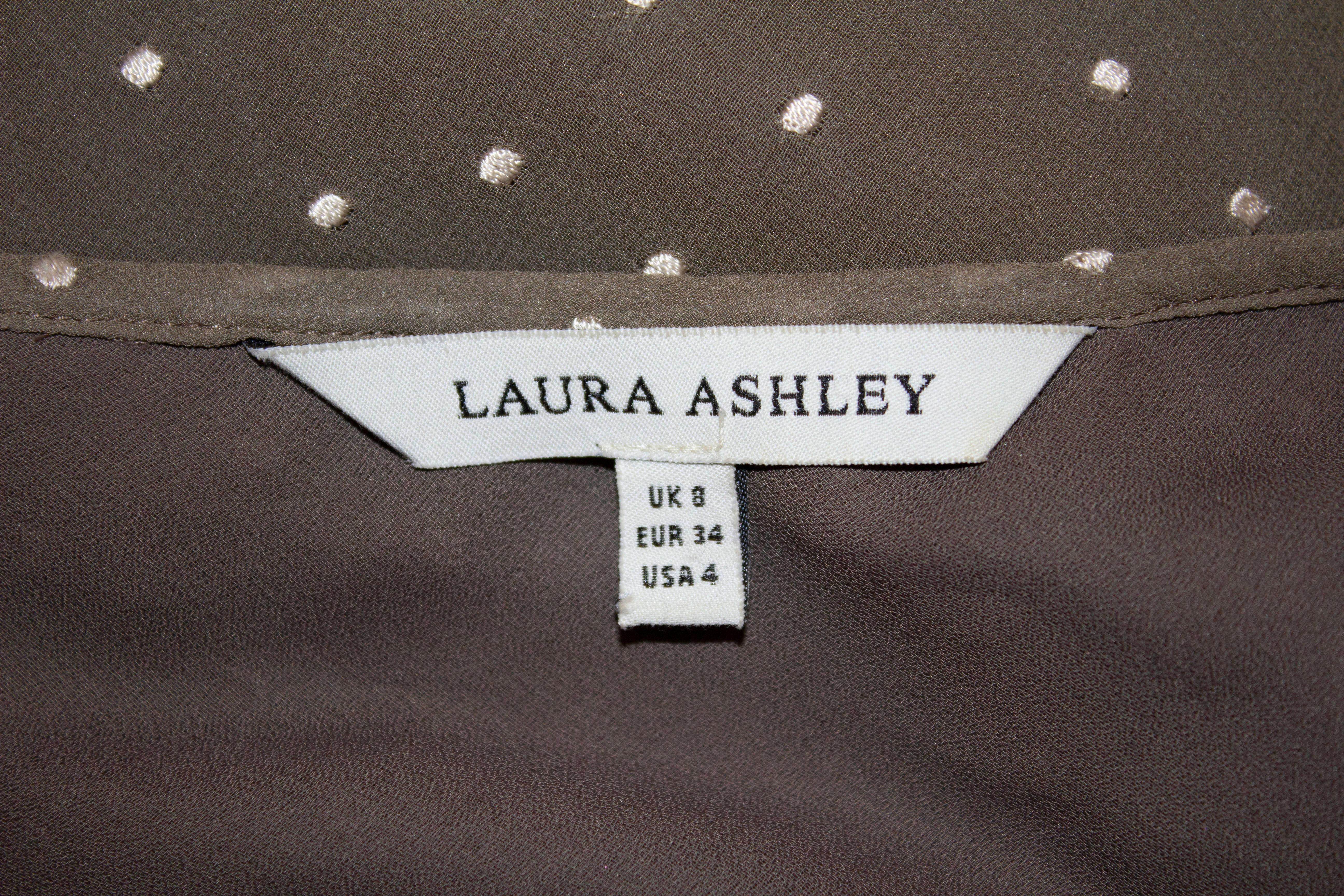 Ein hübsches und leicht zu tragendes Teekleid von Laura Ashley. Dieses kaffeefarbene Seidenkleid mit weißen Flecken hat lange Ärmel, eine Schnürung und eine schöne Form. Es ist vollständig gefüttert. 
Maße: Büste 32'', Länge 48''

