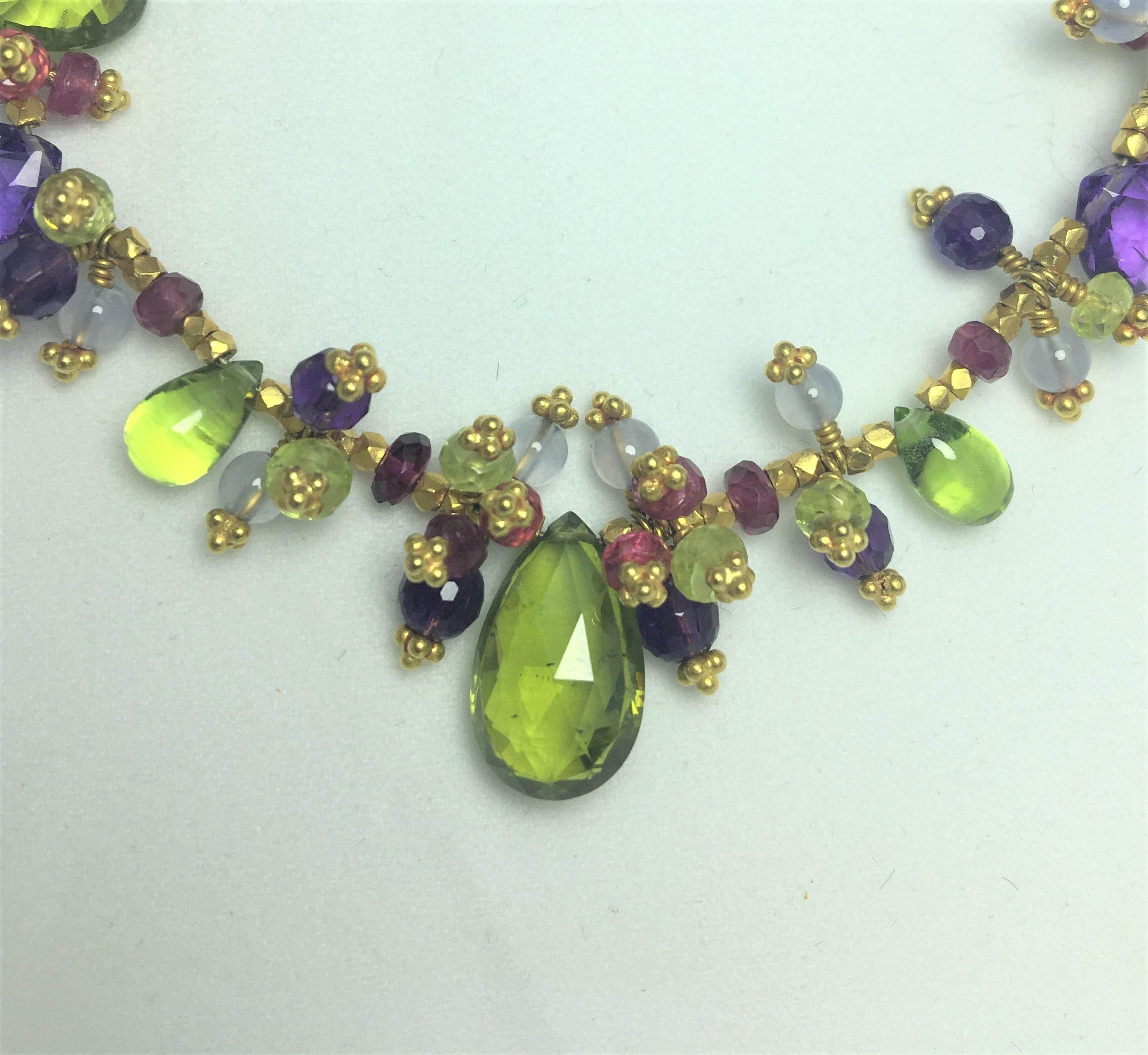 Laura Gibson Multi-Color Gemstone Necklace
Amethyst, Pink Tourmaline, Lemon Chrysoberyl, Chalcedony, Spinel, Peridot and Vesuvianite stones, varying shapes and sizes
64.5 carats total weight
22K Yellow Gold
16 inches long, Natural Length 
Toggle