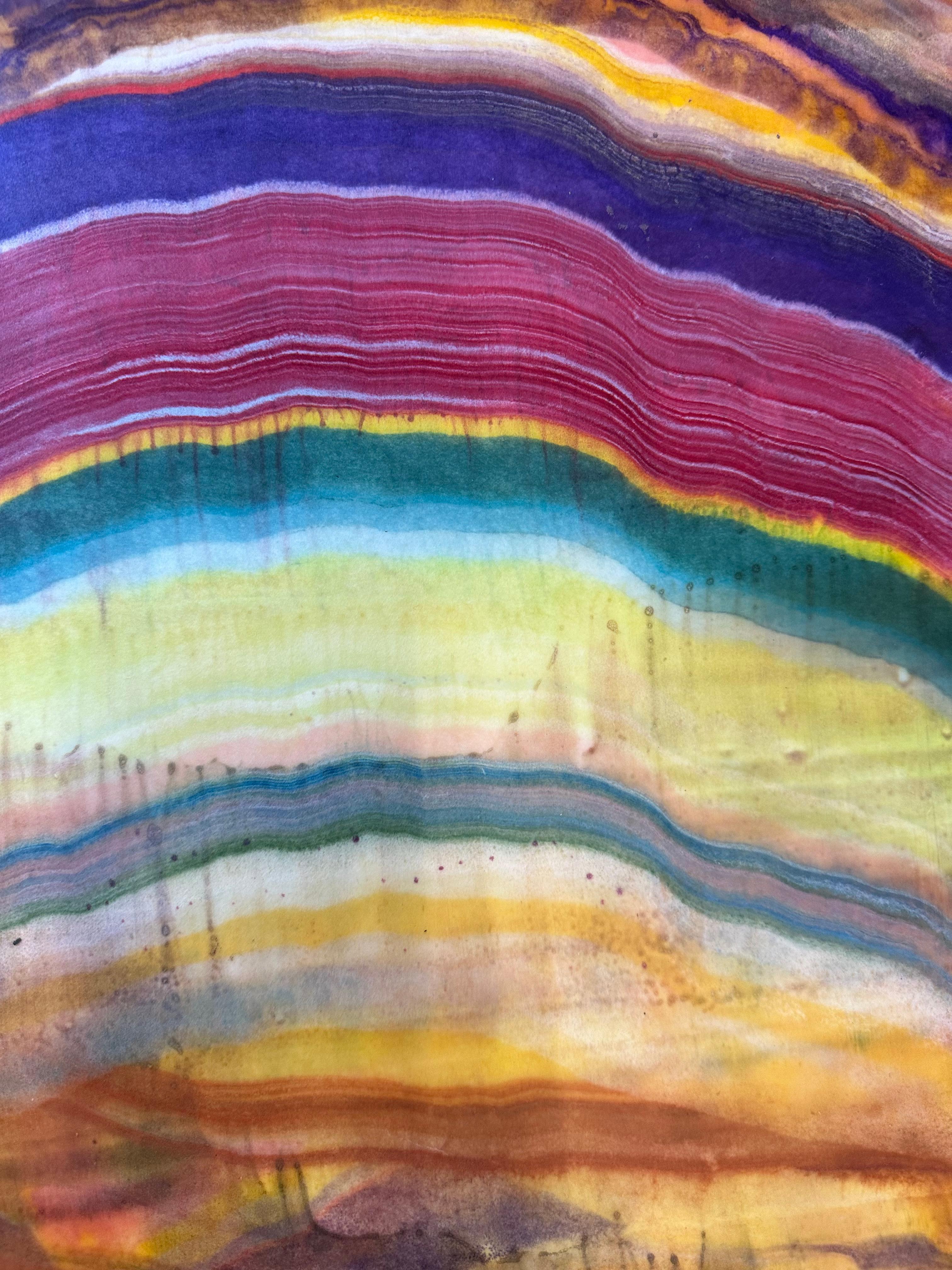 Laura Moriarty's Talking to Rocks 1 is a multicolored encaustic monotype on kozo paper. Layers of pigmented beeswax on lightweight paper create an undulating composition suggesting layers of the earth's crust and geological formations in bright