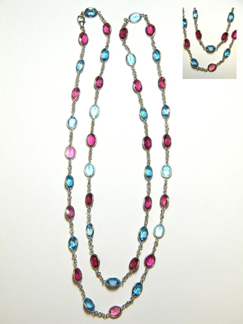 18 karat white gold 31.25 inch chain with oval Pink Tourmaline and Blue Topaz (42) oval  8 x 6 mm stones, 21 Pink Tourmaline approximately 23.52 carats total weight  and 21 Blue Topaz approximately 29.61 carats total weight. Lobster style clasp.