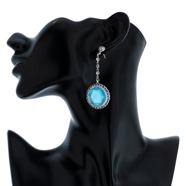 Laura Munder blue topaz, diamond and mother of pearl dangle earrings in 18k white gold.

These earrings feature two modern rose cut blue topaz totaling approximately 12.32 carats, set over mother of pearl.  The earrings contain an additional 4.56