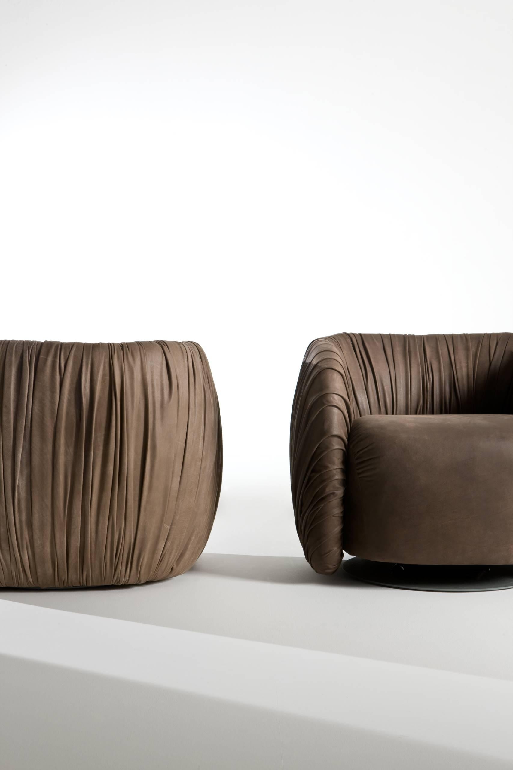 Rotating padded armchair covered with a Cat. B SAVANA leather drapery. Metal base with RAL 7005 