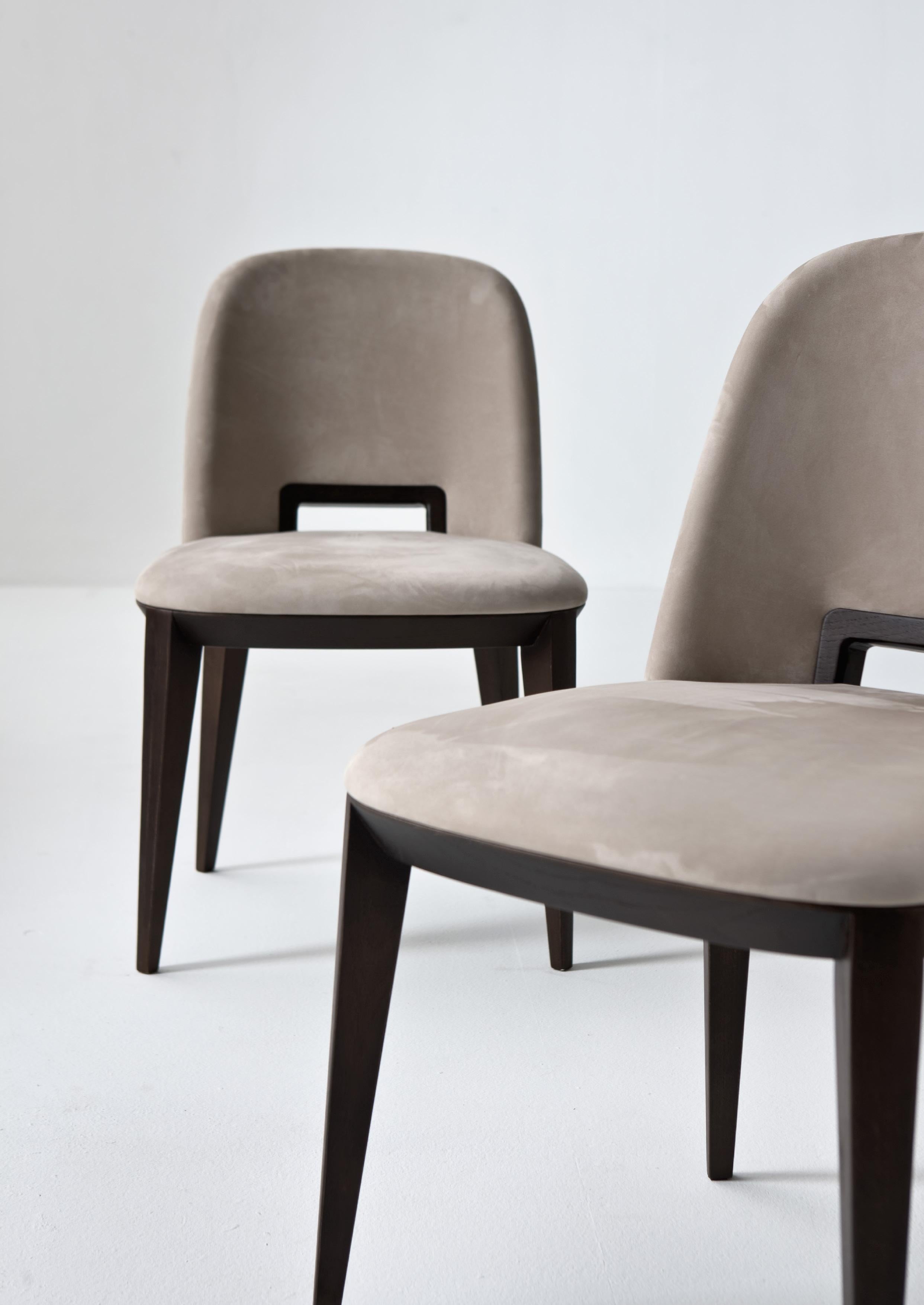 Padded chair with structure in wood painted wenge. Seat and back with polyurethane foam padding covered in Cat. A Nubuck leather.

FINISH:
Cat. A Nubuck leather 2118 and wenge-painted wood

The sinuous line, the well-proportioned legs, the