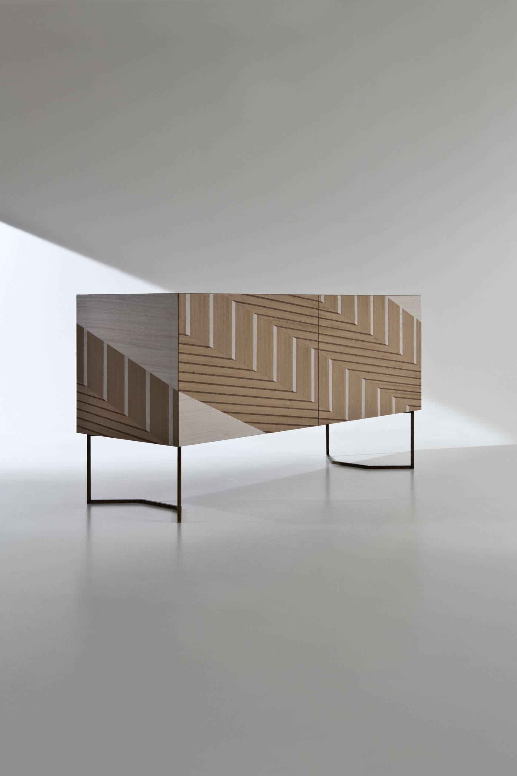 Sideboard with burnished brass legs, inlaid doors and structure. Fitted with push-pull doors, one internal shelf and two drawers.

FINISH:
Limited Edition Art Inlay

Twill is a sideboard enveloped by a mosaic of Eucalyptus, Oak and Tay wood