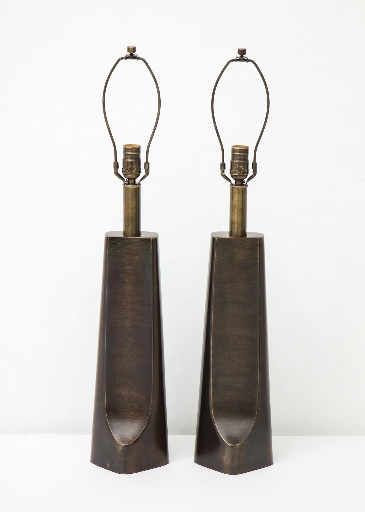 Paire de lampes modernistes sculpturales en bronze vieilli au profil brutal et élancé. Recâblage professionnel pour une utilisation aux Etats-Unis. Ampoules de 100W max.