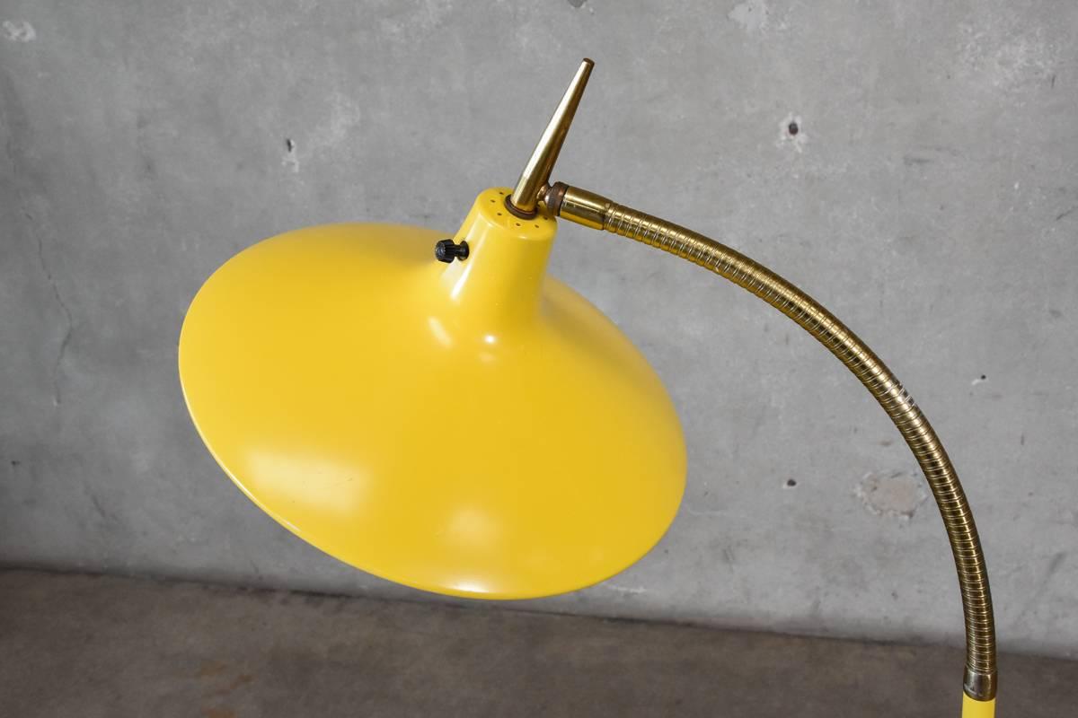 Stunning Laurel floor lamp, in the manner of Gio Ponti, with a brass goose-neck and yellow enamel finish. This piece is in original condition, there is some scratching to the base and to a lesser extent the main shade, there is also some paint