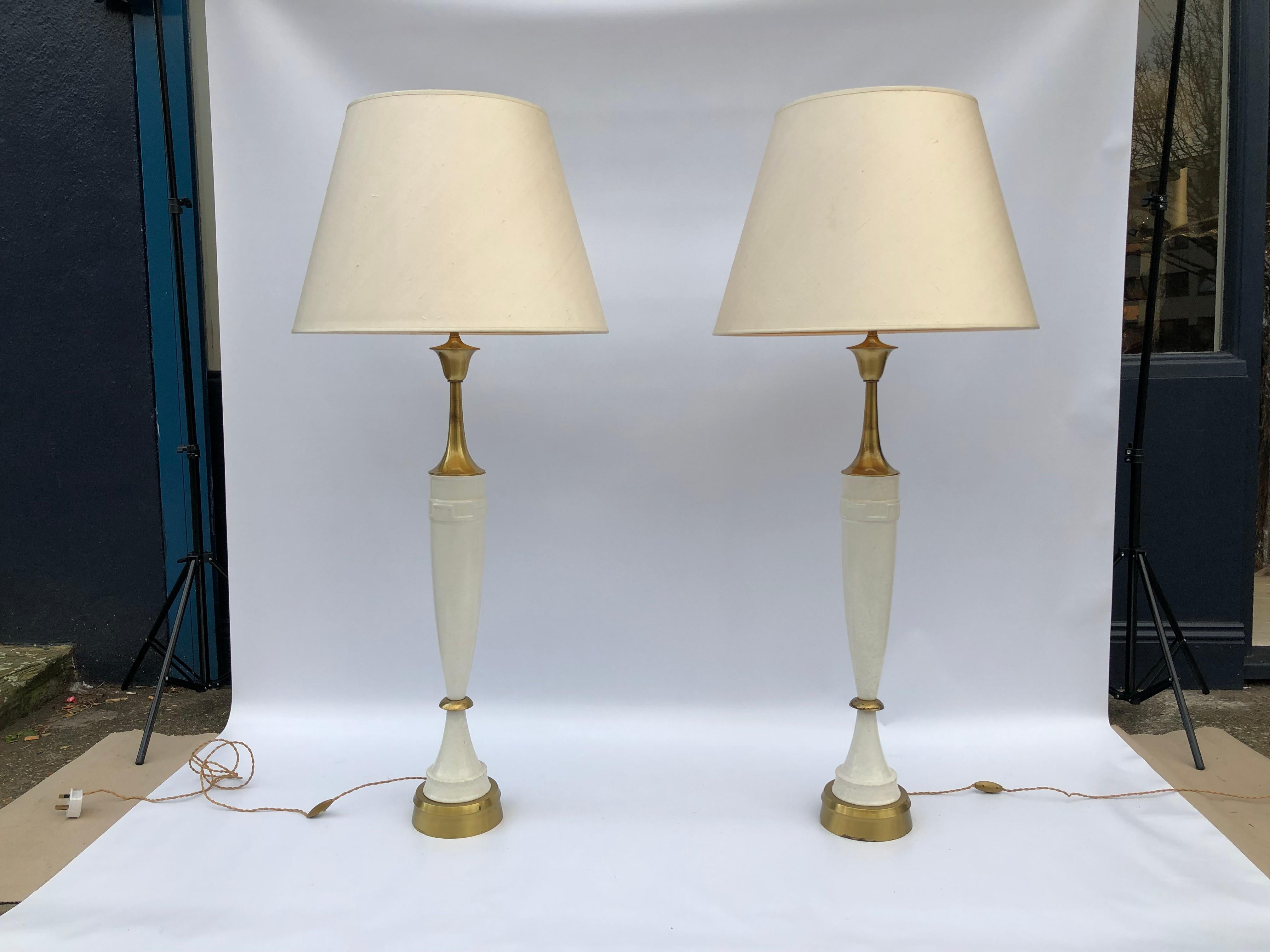 A pair of identical and impressively tall table lamps by LAUREL imported from USA in the early 70s and have been in the same estate since. 

They are made from a stylish cream ceramic and brass elegant finishings. There is a neo-classical element to