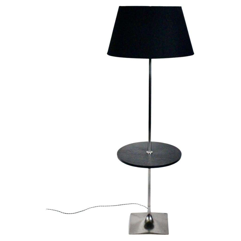 Laurel Lamp Company chrome floor lamp table with black slate side table.
Featuring a chrome plated tubular stem a top a balanced flared (10 x 10) chrome plated cast aluminum base with circular (16
