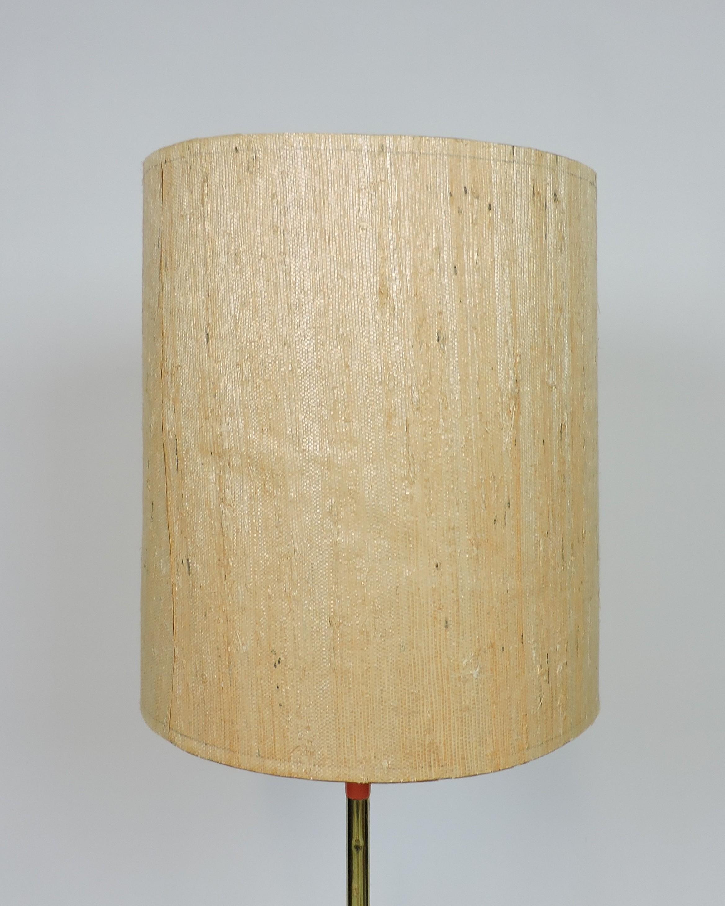 Lampe sur pied très cool et inhabituelle fabriquée par un fabricant de luminaires de haute qualité, Laurel Lamp Company de Newark, NJ. Cette lampe bien faite a une base tripode en métal orange, une tige en laiton et l'abat-jour tissé d'origine. Il