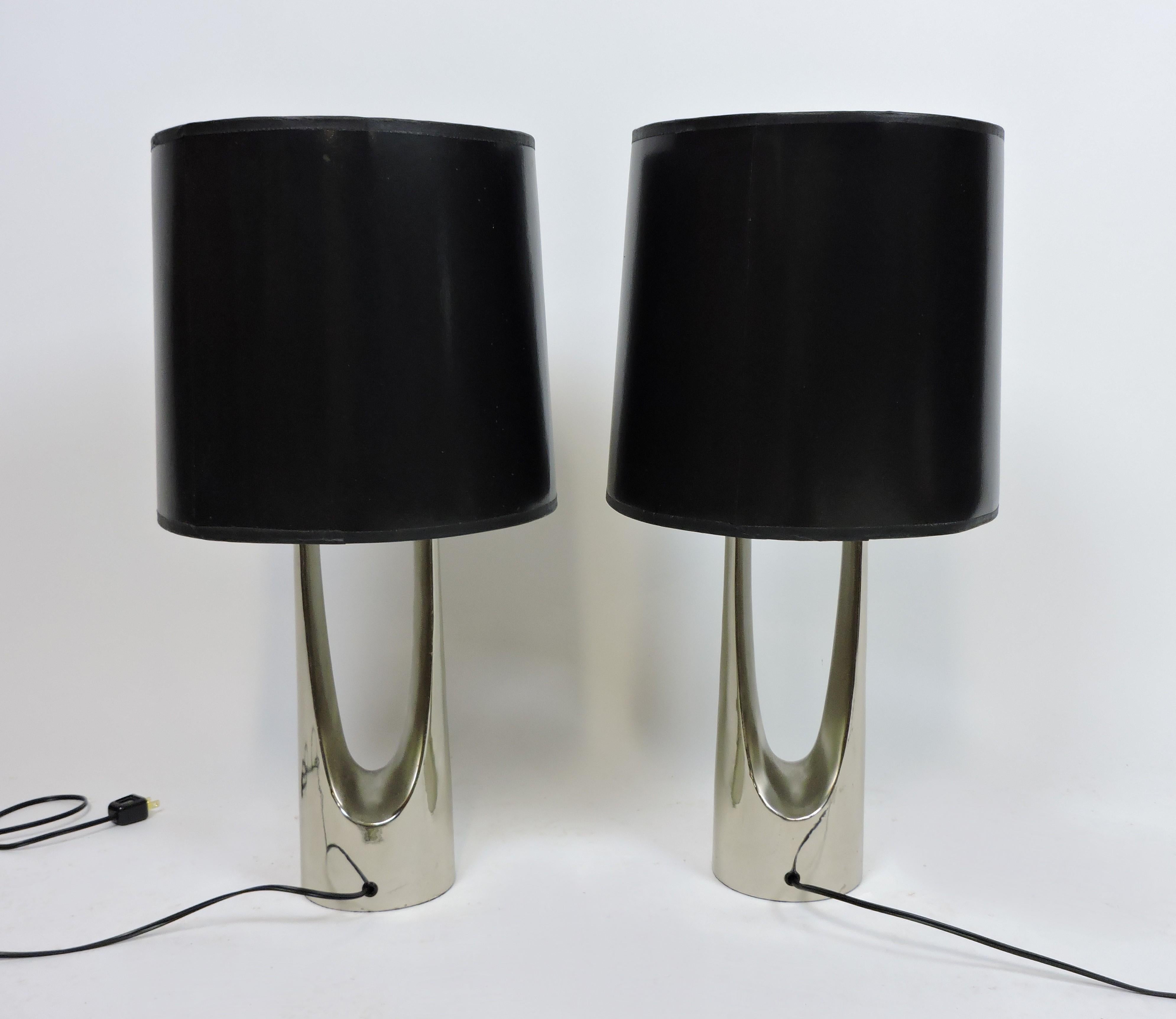 Striking pair of table lamps made by high quality lighting manufacturer, Laurel Lamp Company of Newark, NJ. These heavy and well-made lamps have chrome enamel finished metal bases in a wishbone shape and the original shades and finials. They have
