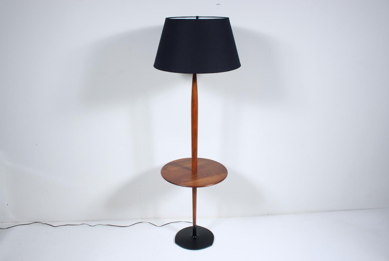 Laurel Lamp Company Beistelltisch Stehlampe aus Nussbaum und schwarzer Emaille.
Mit einem stabilen, ausgewogenen Gestell, einem sich verjüngenden Stamm aus Nussbaumholz, einer runden Tischplatte aus massivem Nussbaumholz (17D) und einem