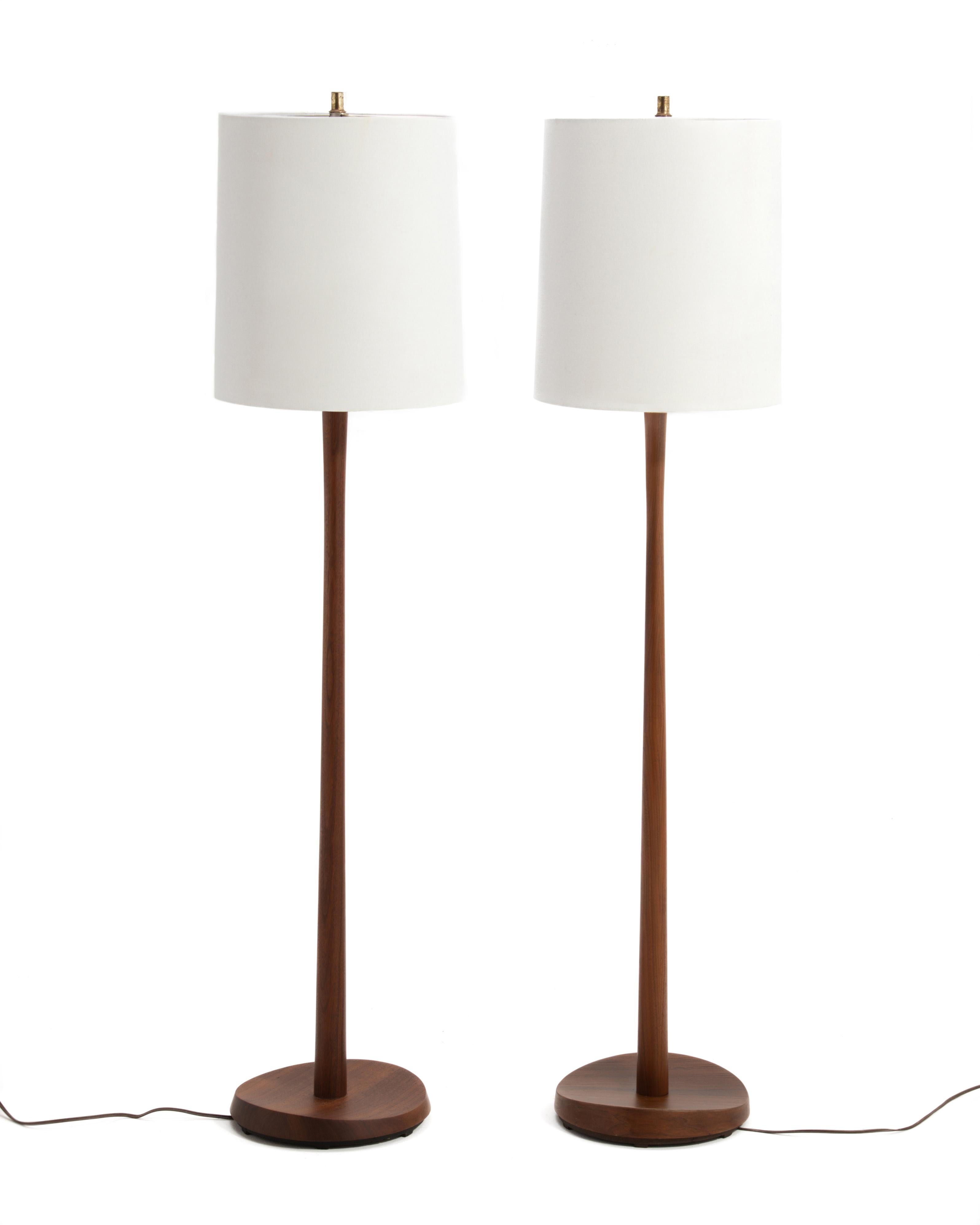 Paire de lampadaires en teck de la Laurel Lamp Manufacturing Company avec des bases sculpturales. Identiques en taille et en présentation, mais pas en fabrication. Une lampe a une base en teck massif et la seconde a une base plaquée. Pour un