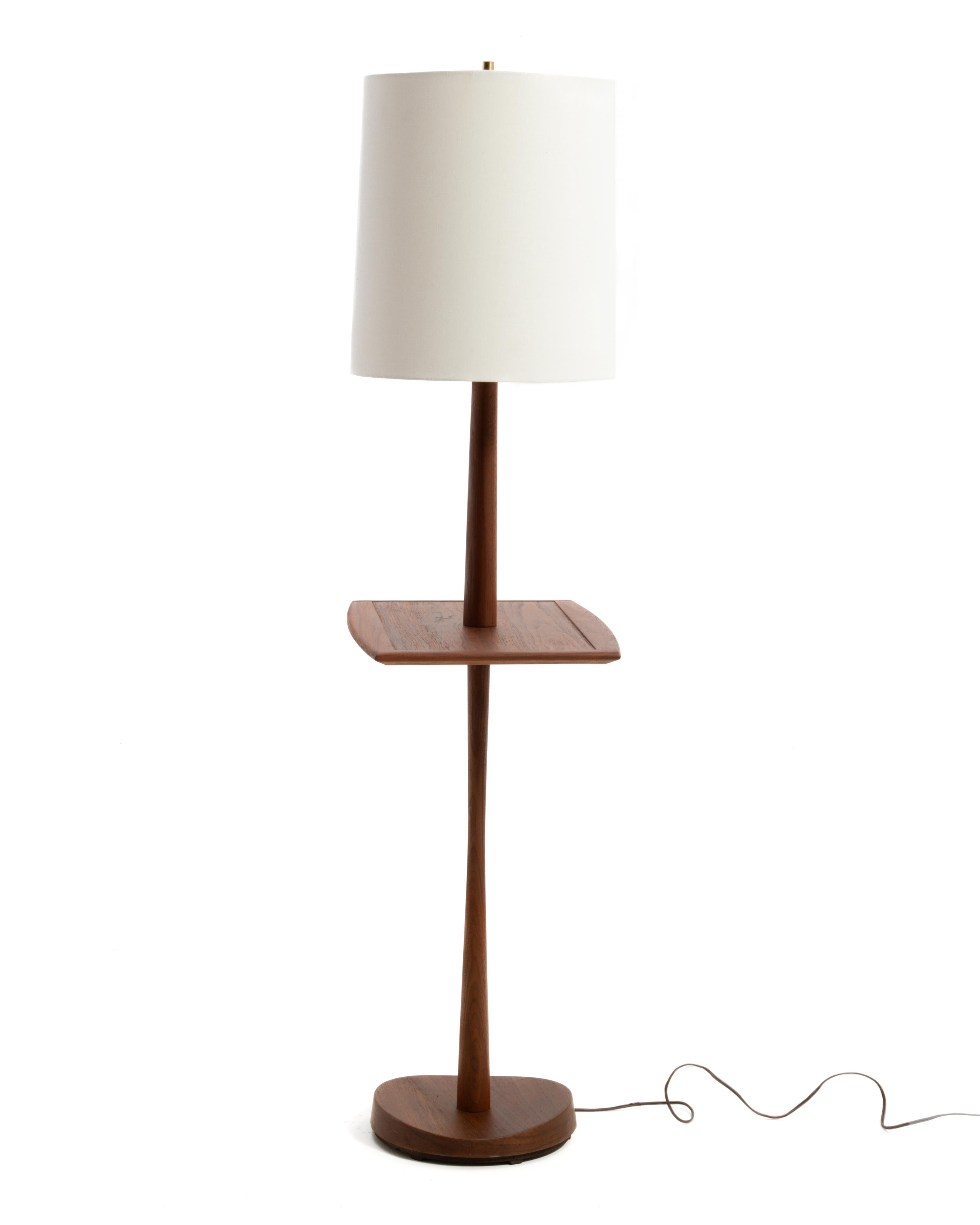 A Mid Century teak floor lamp made by the Laurel Lamp Manufacturing Company. The lamp features a very useable boat shaped table or shelf. Solid teak column and frame, sculpted and veneered base. AN iconic piece...

Unmarked, the base is identical to