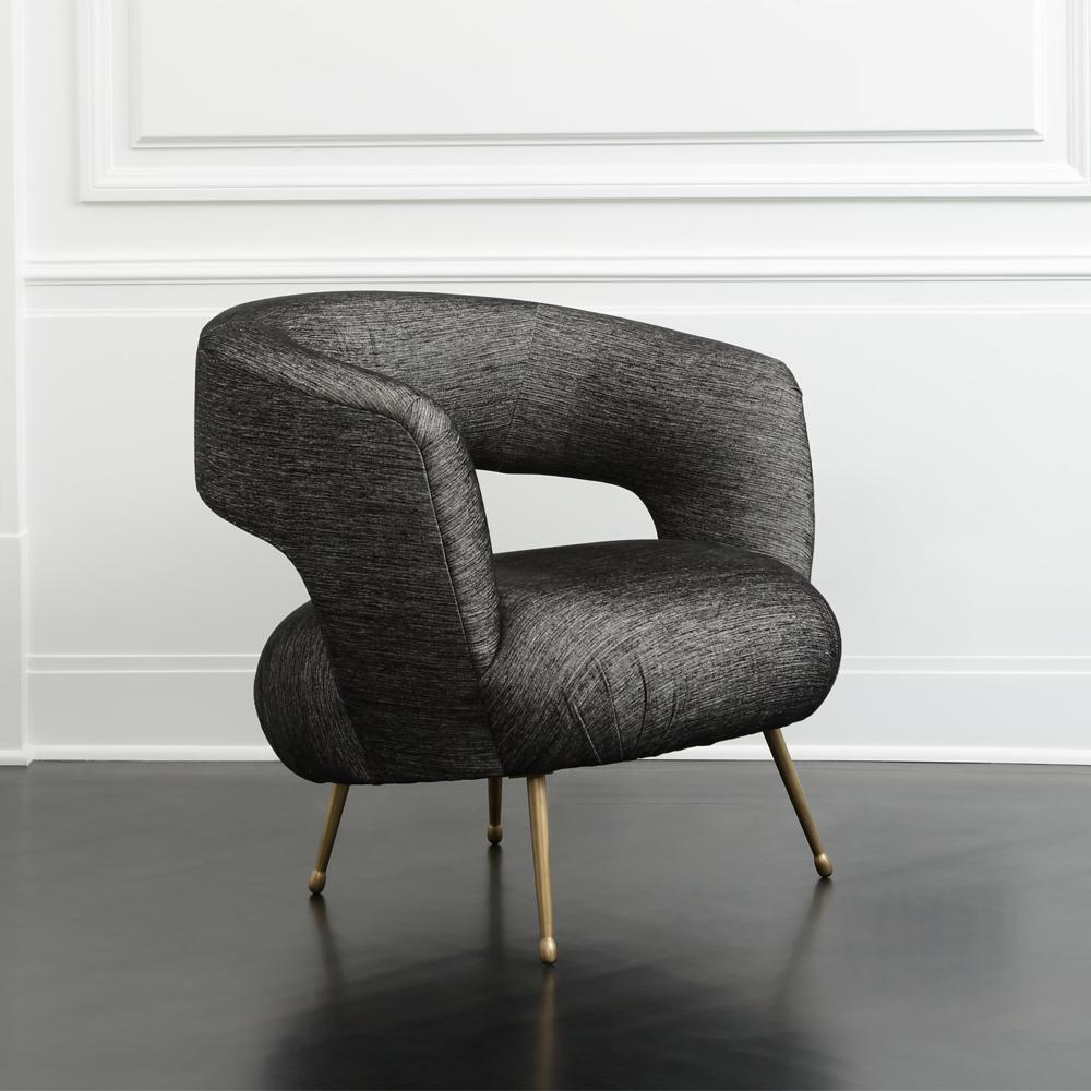 Inspired by Kelly’s signature soufflé chair shape, the Laurel lounge chair features a dramatic swooping, curved back, tight upholstered seat, and open back. It rests on tapered cast brass legs in burnished bronze with an elegant, teardrop foot.