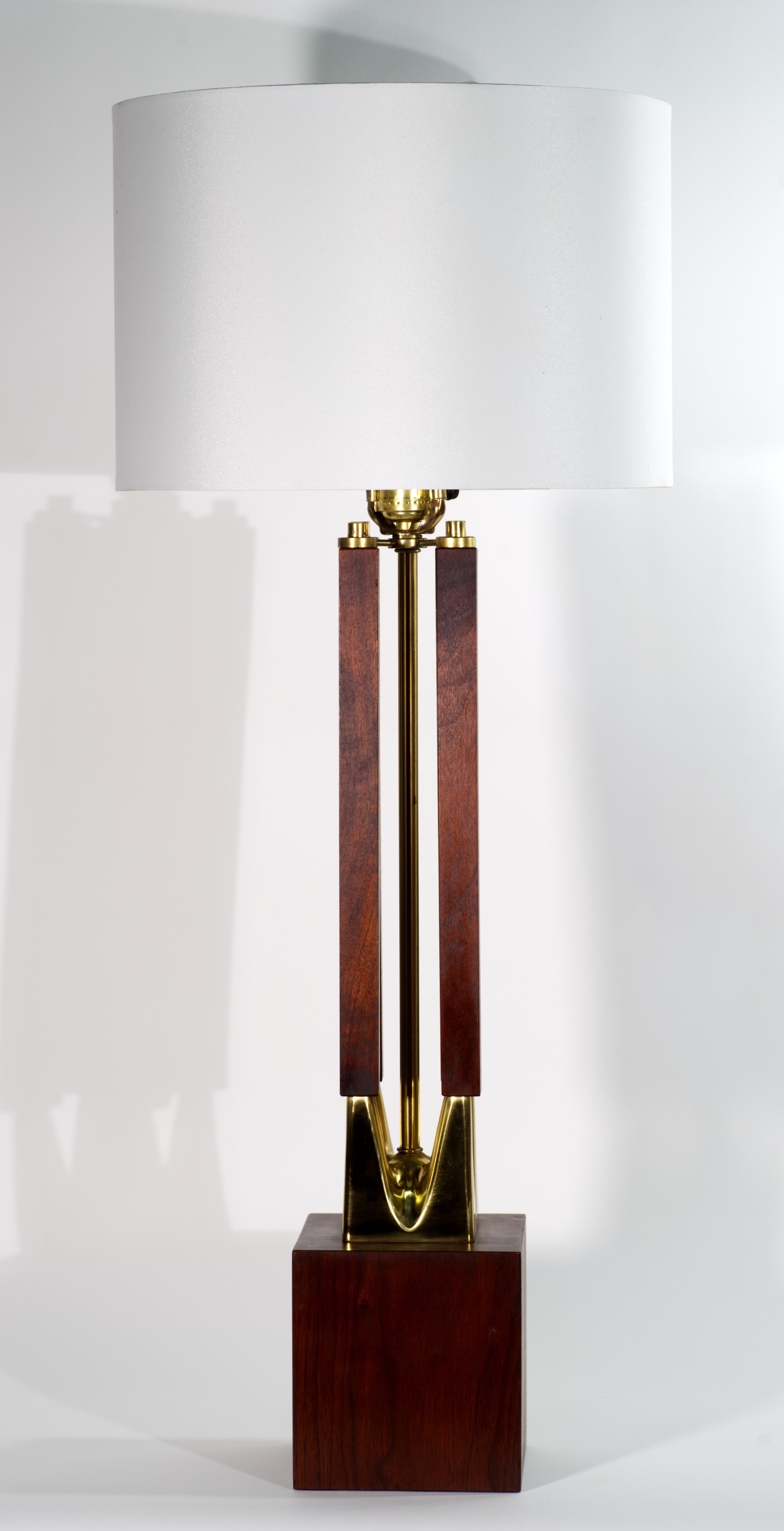  Lampe de table en noyer et laiton de style moderne du milieu du siècle, composée d'un groupe sculptural de quatre colonnes en noyer massif soutenues par des détails en laiton moulé et montées sur une base en noyer massif. Sa forme graphique et