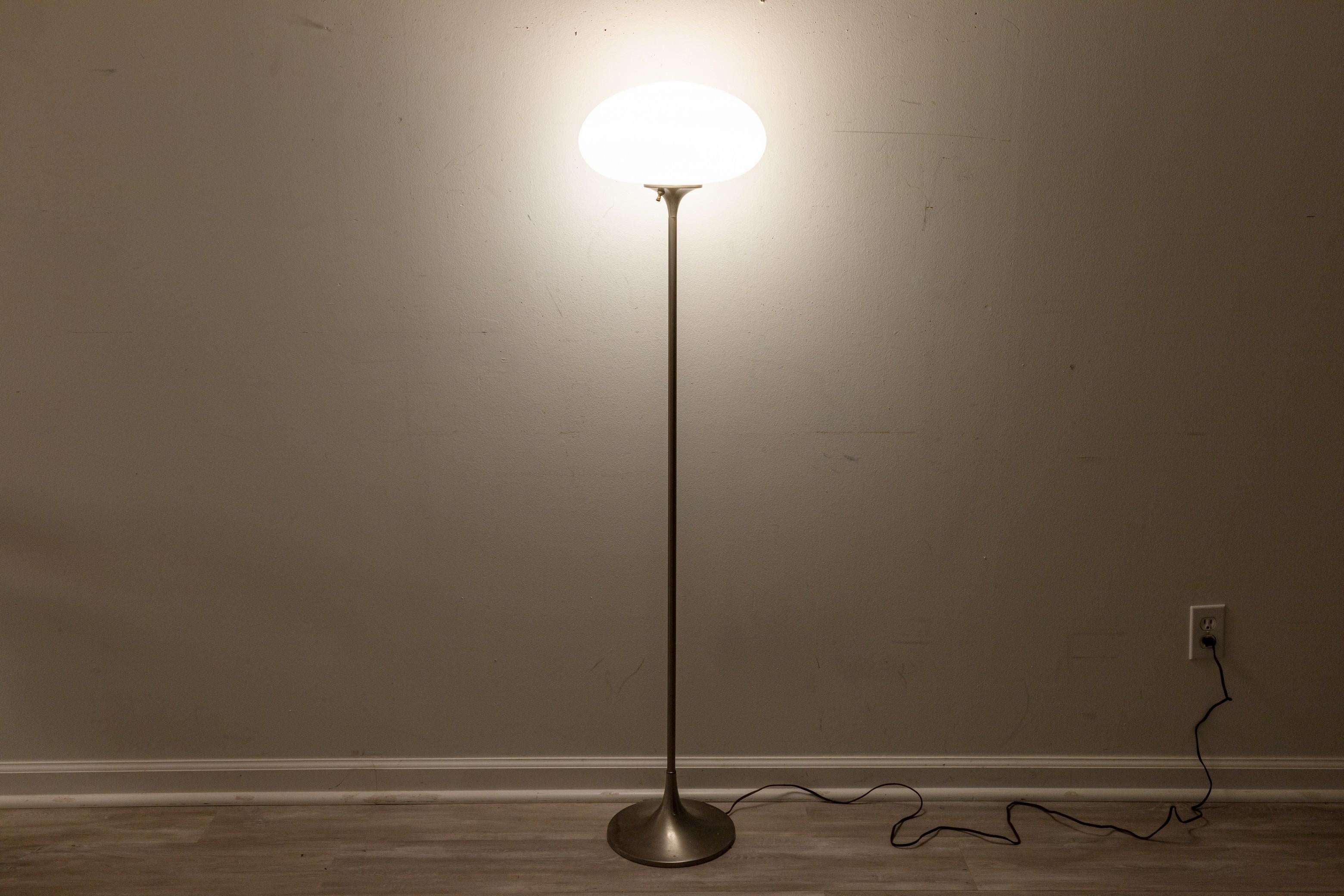 A Laurel Lamp Company mushroom floor lamp. A lovely mid century modern floor lamp featuring a brushed metal base and center pole, and a removable white smoked glass lamp shade. This beautiful floor lamp has a small analog knob to turn the light on