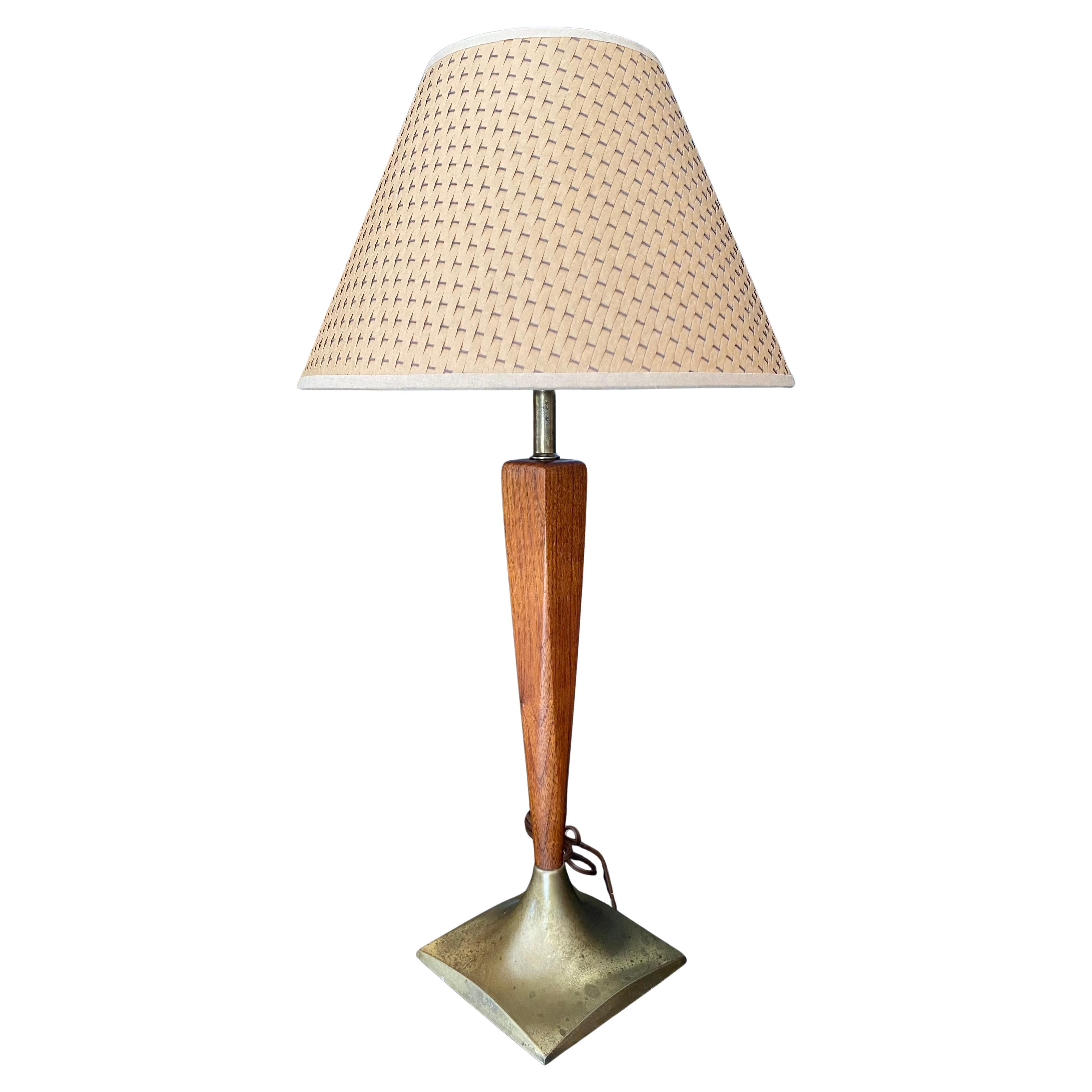 Midcentury Modern pair of walnut and brass table lamps. Heavy bases maintain a beautiful age-worn patina that contrasts the walnut grain. Both lamps tested and work properly with original wiring. New woven shades are included.

Perfect on a console,