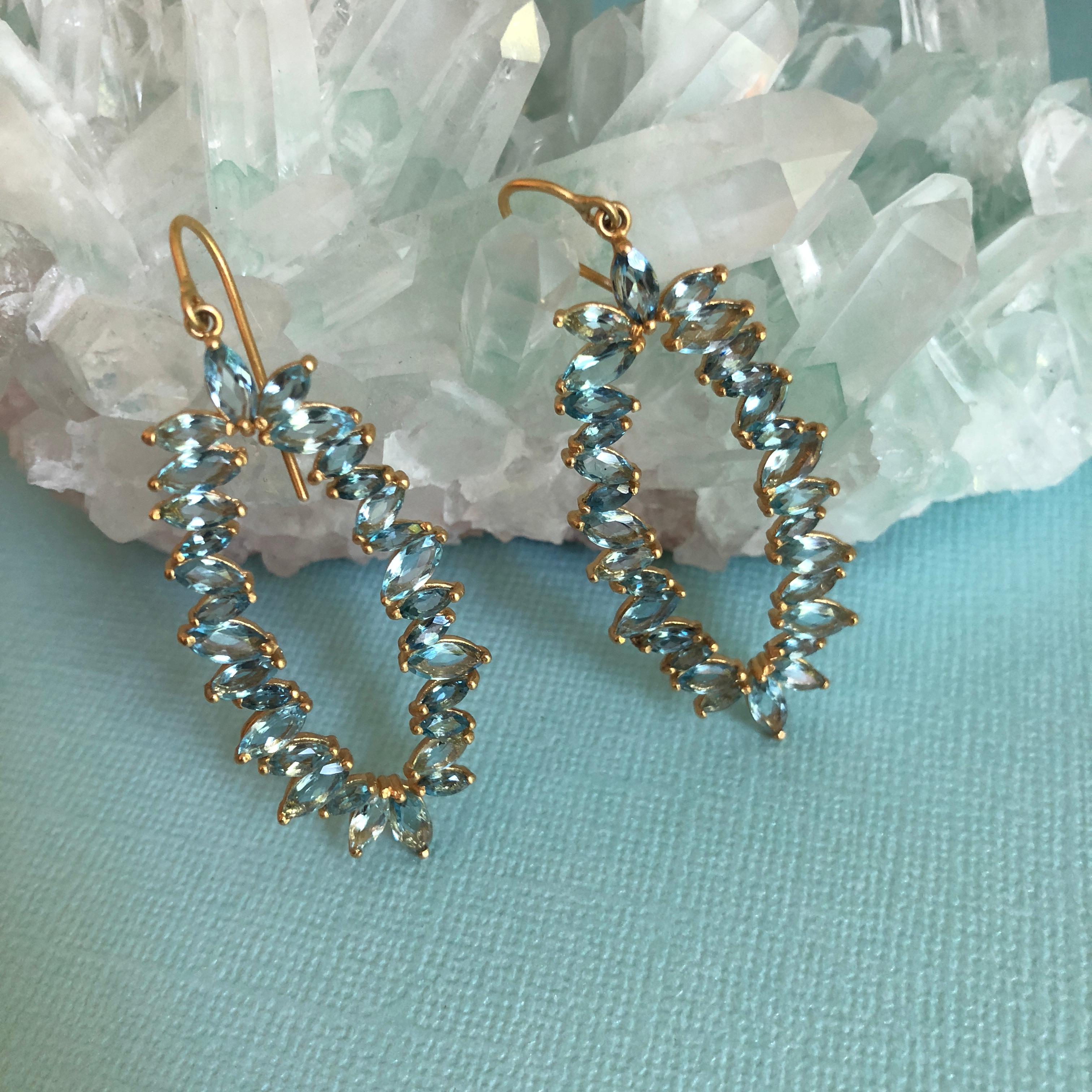 These brilliant blue 7.33 cts marquis shaped Aquamarines are set in a nearly invisible prong setting, allowing the stones to sparkle and dazzle in your ears.  Set in 18kt Gold and open in the middle, these earrings are lightweight and perfect for