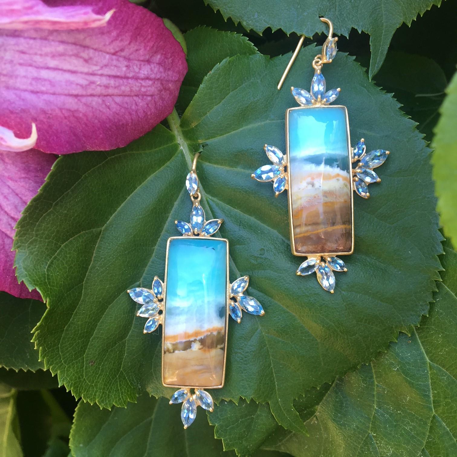 These spectacular Opalized Petrified Wood rectangular cabachons are surrounded by marquis brilliant Aquamarines.  Center stones have a beautiful natural landscape within them that resembles waves crashing on the ocean and sand on the beach.  Set in