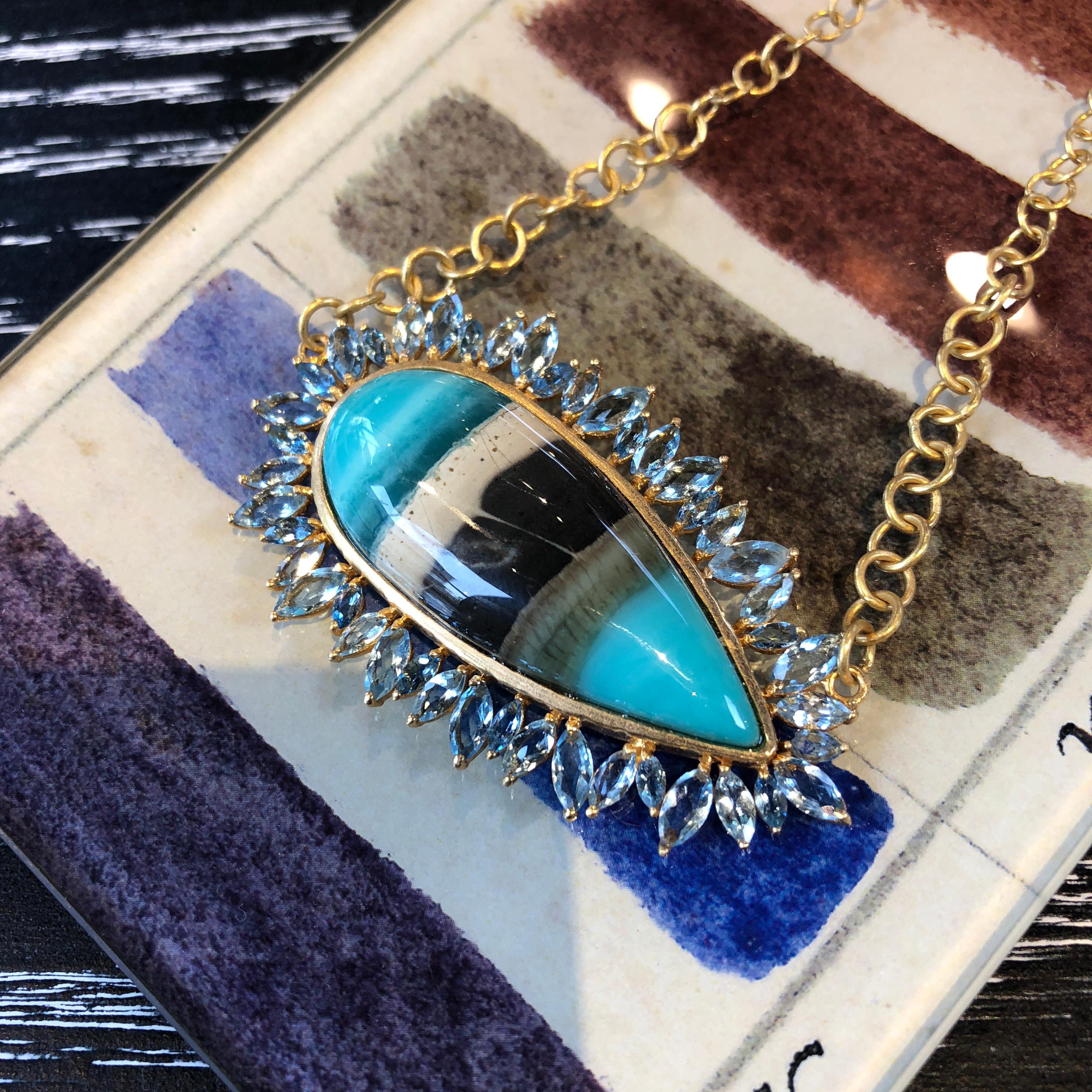 This spectacular Petrified Opalized Wood Pear Cabachon is set sideways with marquis shaped faceted Aquamarines surrounding the center stone.  This piece is perfect for someone who appreciates one of a kind jewelry, and organic design.  The necklace