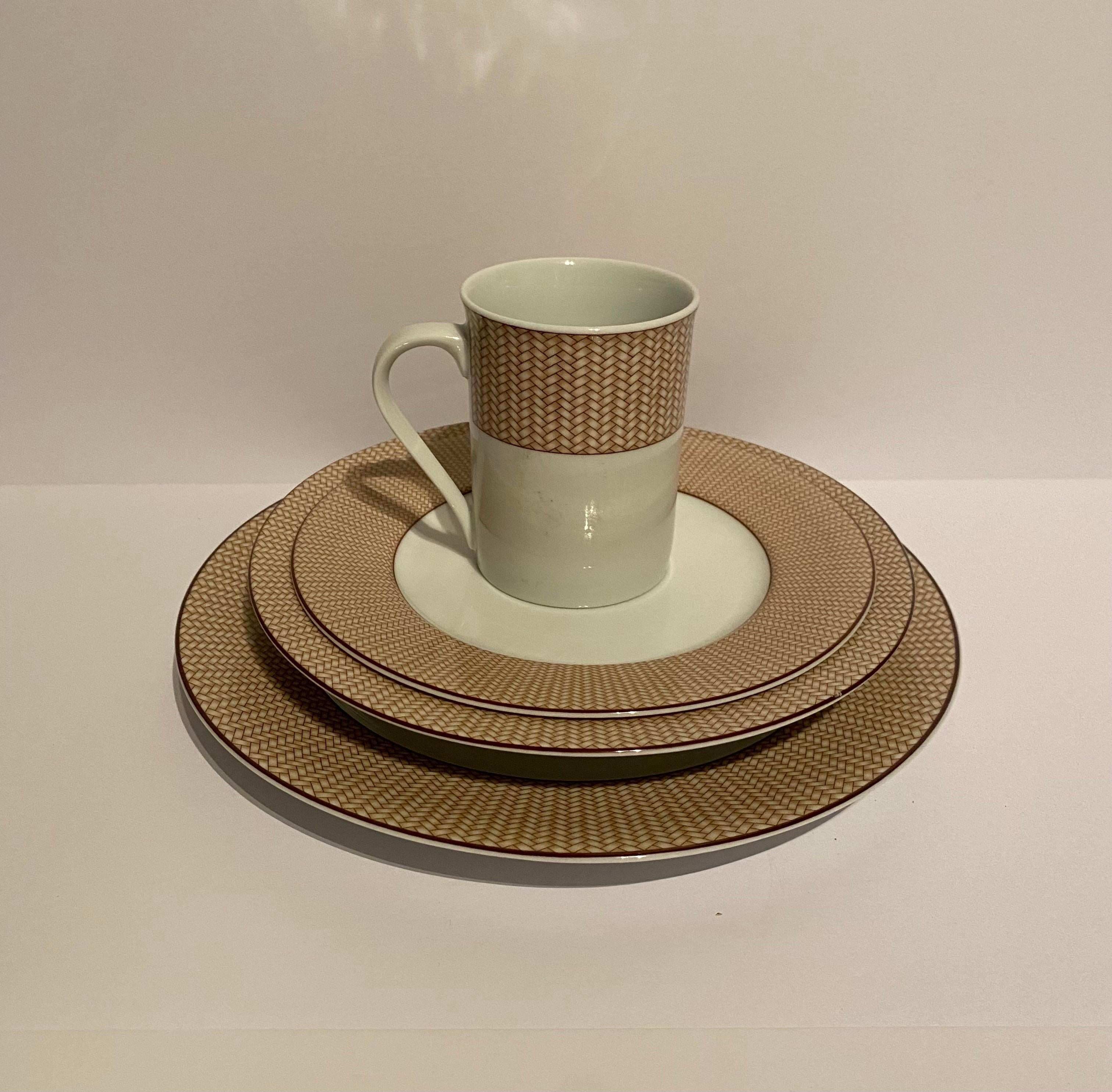 A 32 (thirty-two) piece set of dinnerware by Lauren/Ralph Lauren in the Reed Natural pattern.

Features a tan wicker patterned border on white complemented by brown trim.

Includes 8 four piece-settings; each setting includes the following 8