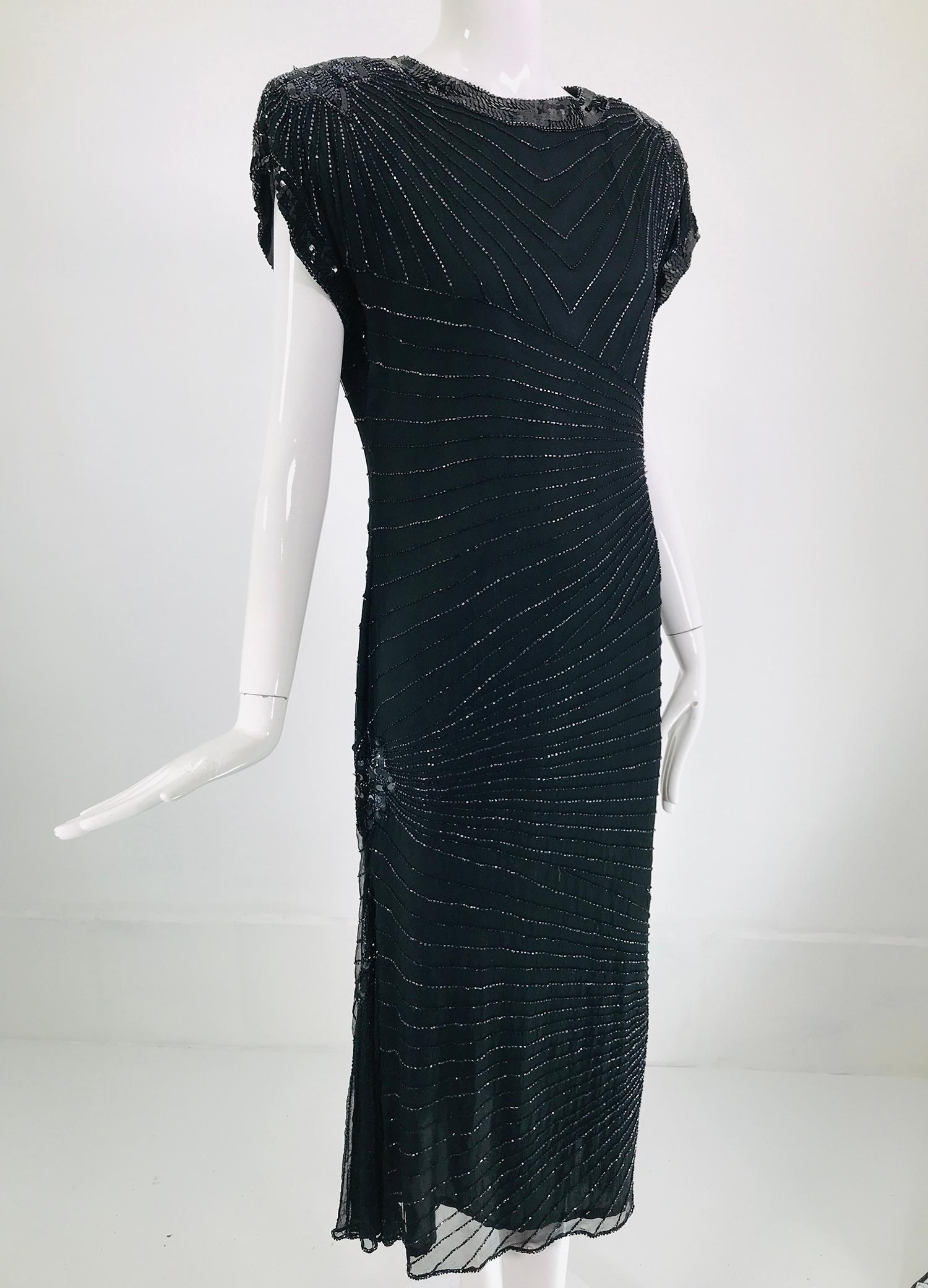 Laurence Kazar black silk beaded & sequin circle back cocktail dress from the 1980s. Cap sleeve dress is fitted through the body and flares at the hem sides & center back with a dip at the hem back. Geometric, art deco beaded design throughout. The