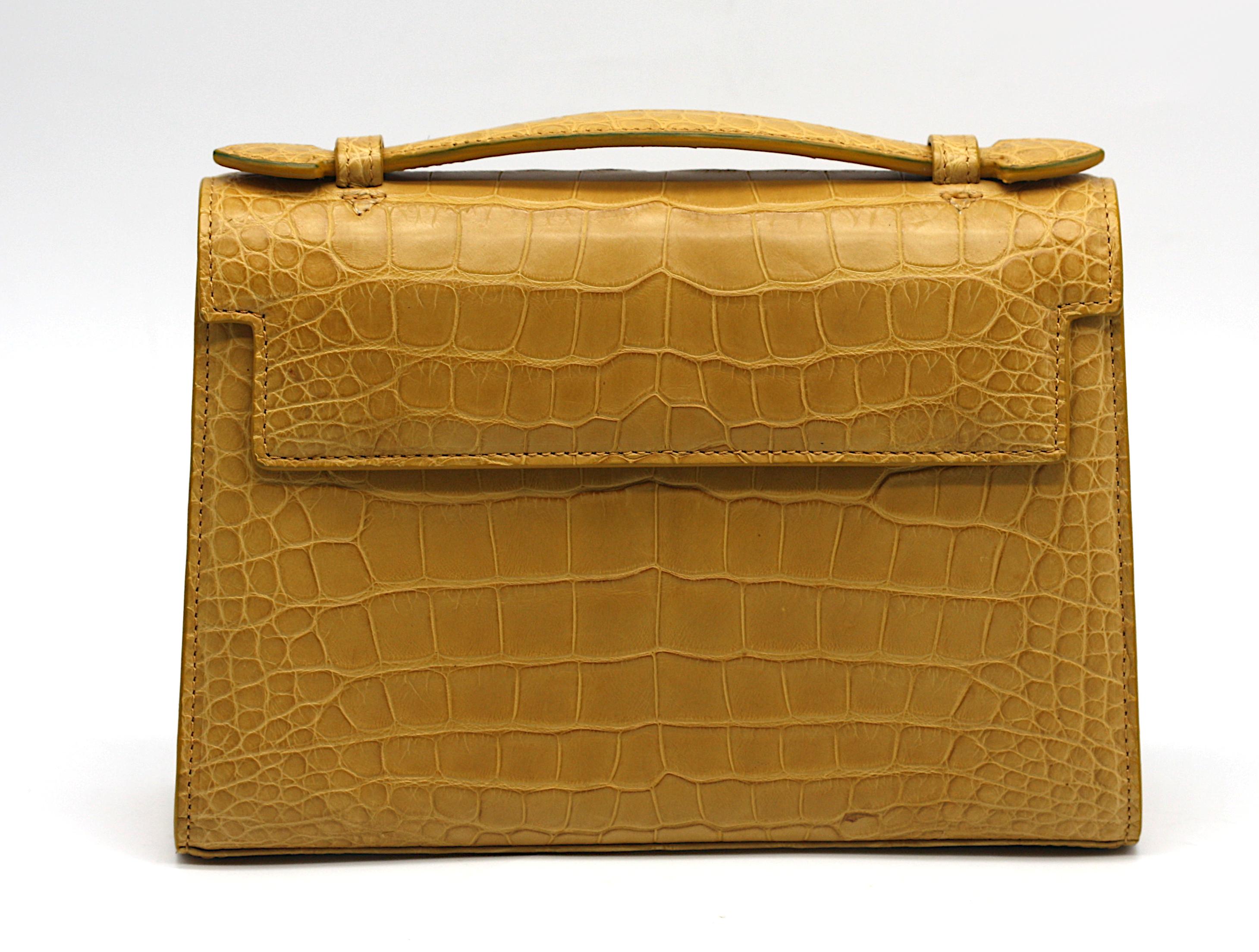 Laurent Effel
Sienna Yellow Alligator Handbag
Rectangular in form, this vibrant piece is rendered in glossy Sienna yellow alligator, accented with a magnetic flap closure. The design features a discreet hand-hold, a leather-lined interior fitted