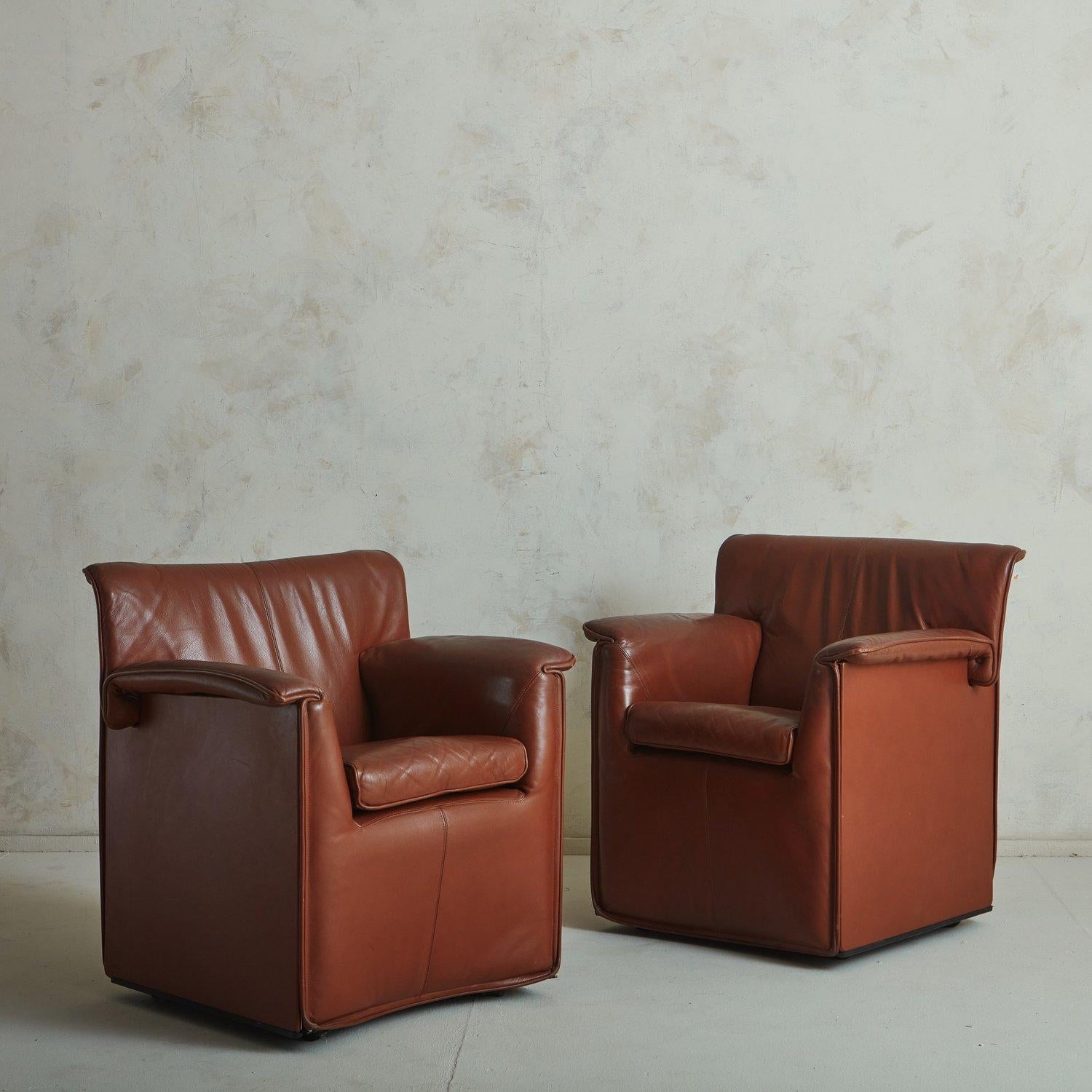 A set of ‘Lauriana’ chairs designed by Afra + Tobia Scarpa for B&B Italia in 1978. These chairs retain their original patinated cognac leather upholstery with stitch detailing. They feature stately profiles with circular button details on the back,