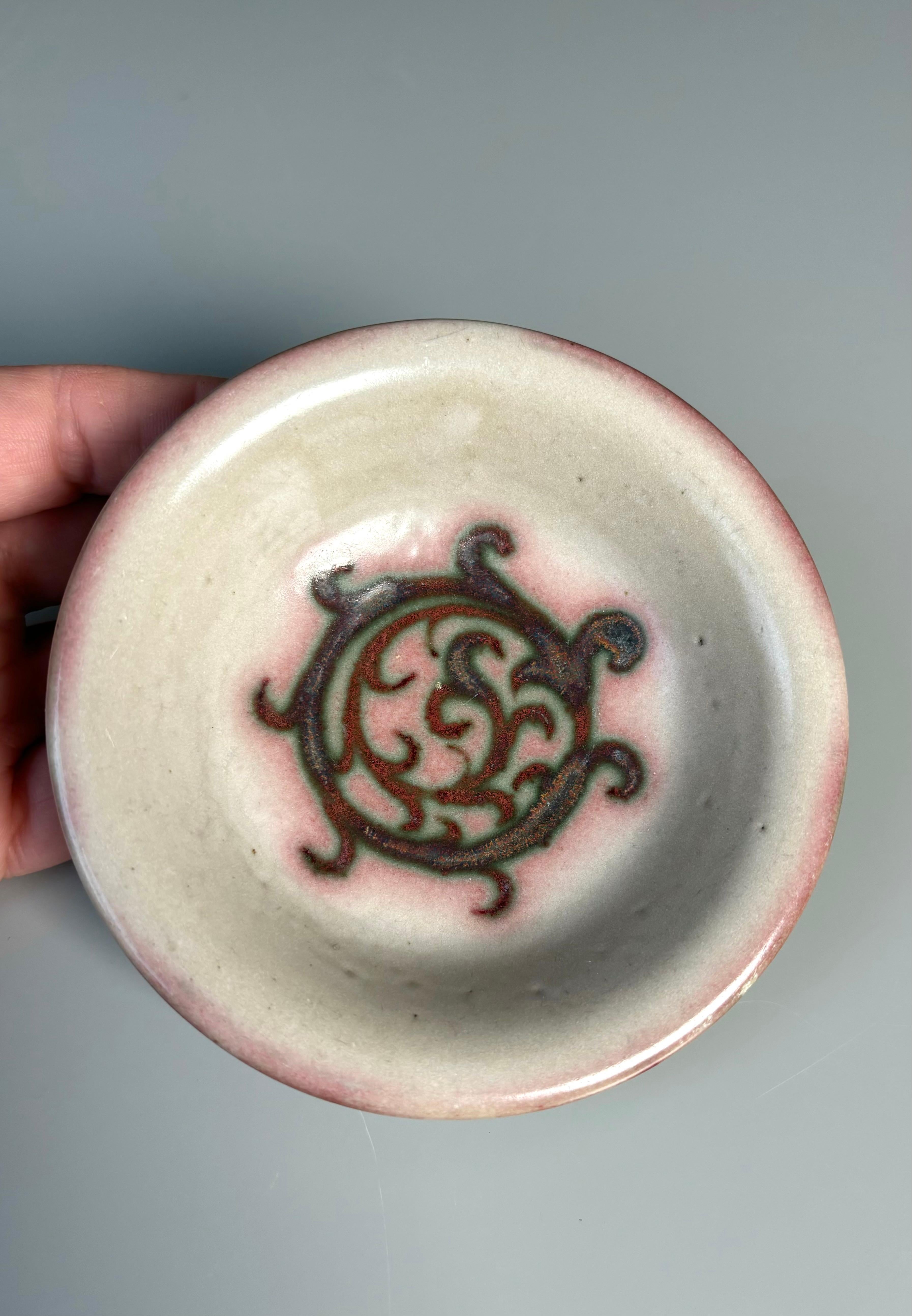 Petite coupe vide-poche danoise art nouveau des années 1940 en céramique à décor organique rose et bordeaux sur glaçure grise chaude. Fabriqué sur l'île de Bornholm par Lauritz Hjorth dans les années 1940. Estampillé du nom du créateur et du logo de