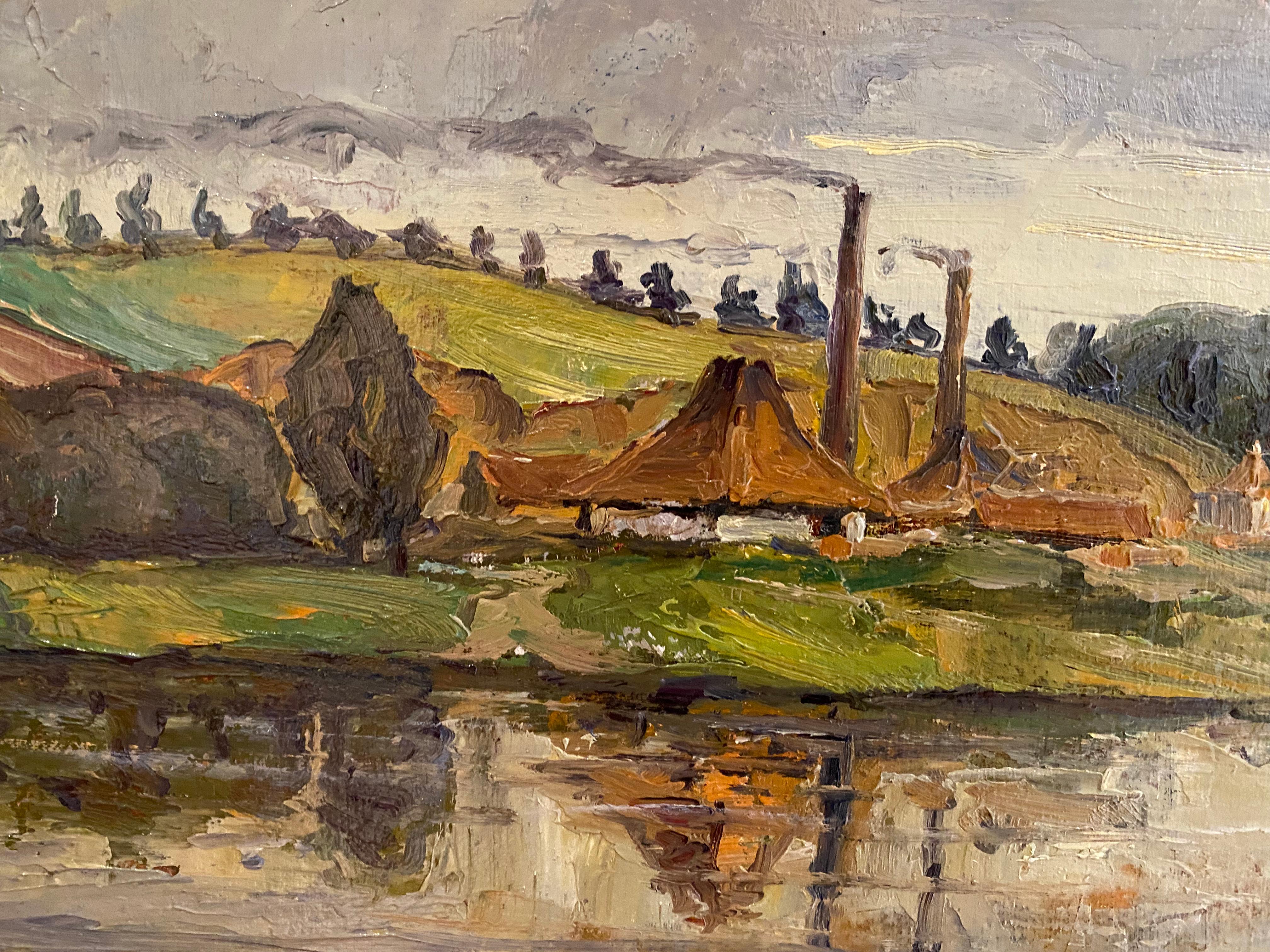 This traditional landscape painting by Lauritz Howe features a predominant blue river and sky with treed landscape of green in the mid-ground. Buildings with two smokestacks line the waterway with smoke traversing the sky. The period frame is gold