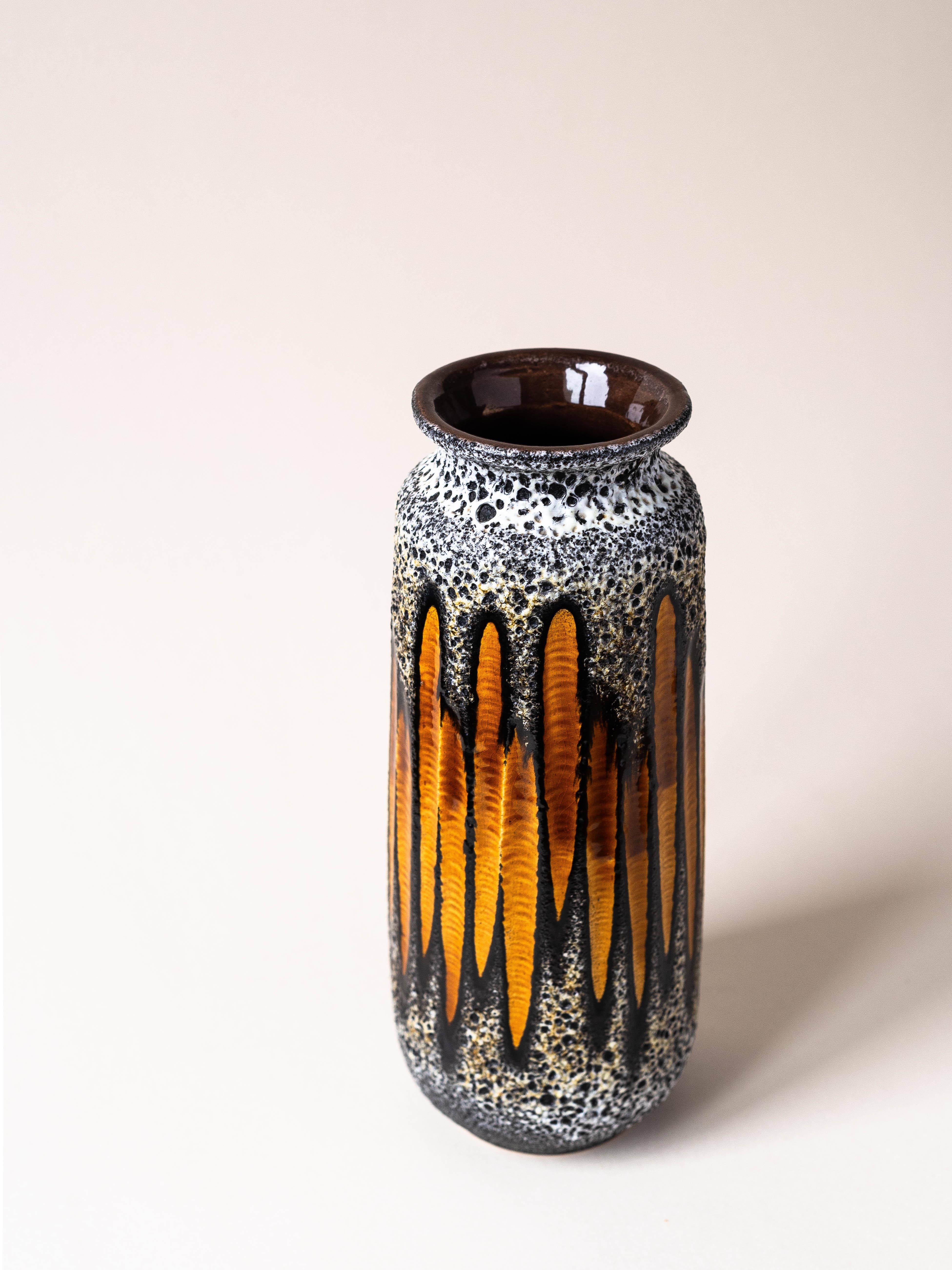 Vase en céramique Lava, Allemagne de l'Ouest, vers 1970.

Joli travail sur les motifs géométriques orang, qui sont émaillés dans une finition brillante. 

Bon contraste avec la finition générale de la lave, avec un aspect mat.

Une pièce de choix ! 