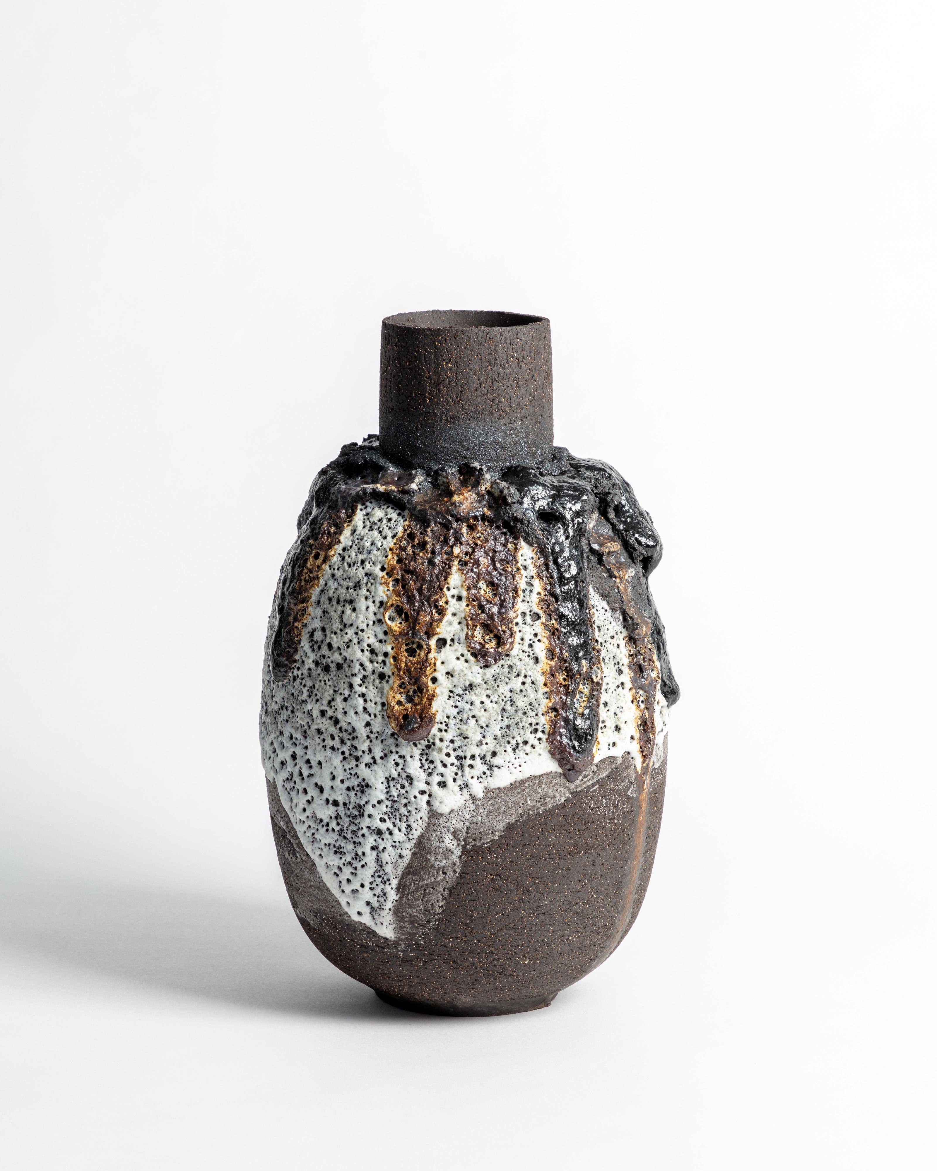 Vaso con smalto lavico in bianco e nero con pietra vulcanica e limatura di ferro

L'opera è costruita a mano utilizzando una combinazione di argille nere e di argille di bufala, con l'aggiunta di barbottine vulcaniche sotto lo smalto. Le cotture