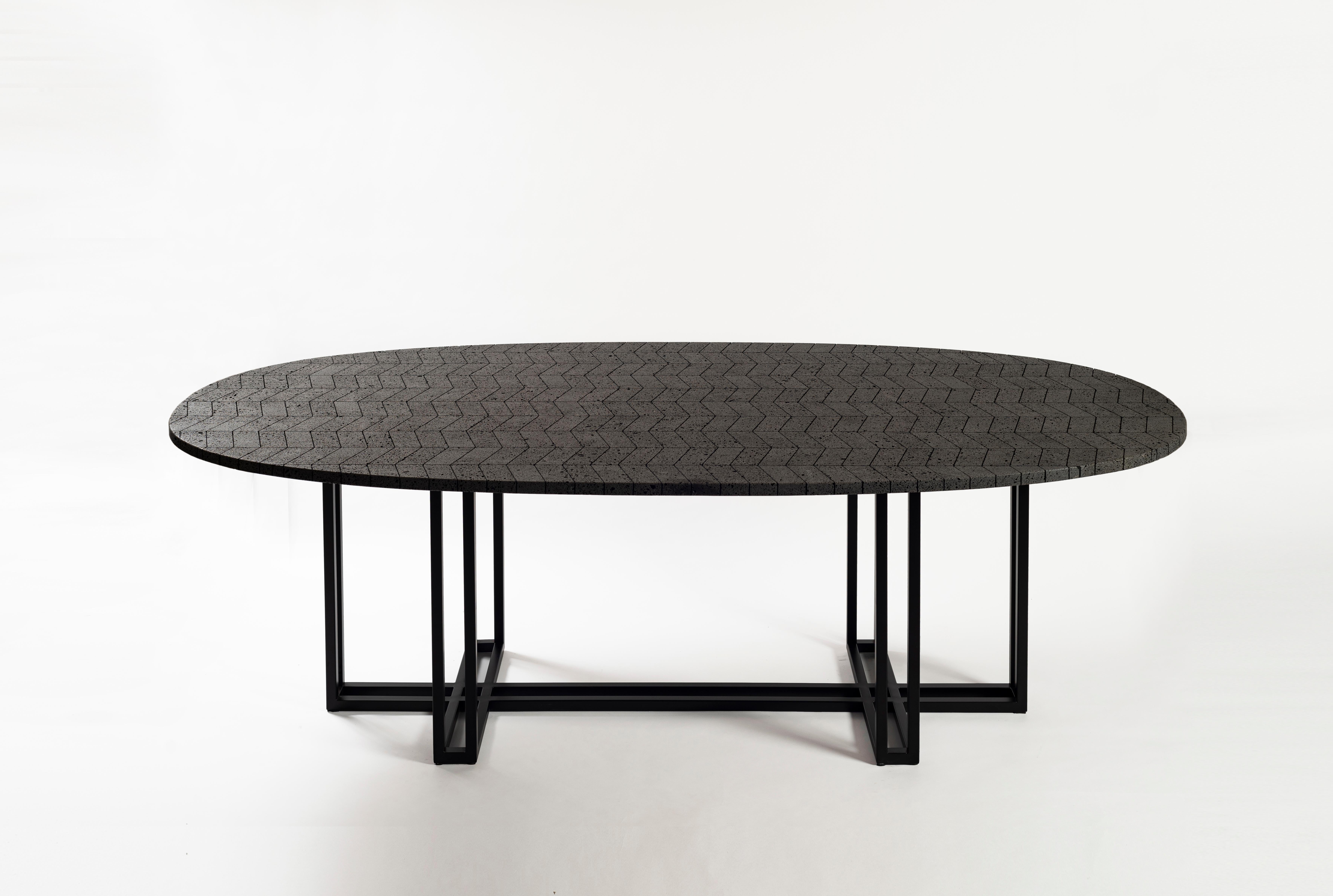 The vast volcanic stone stretches across an oval top featuring a composition of handcut, polished and mounted pieces. The black stainless steel base provides character and strength. This Lava table is ideal for adding its energetic feel to both