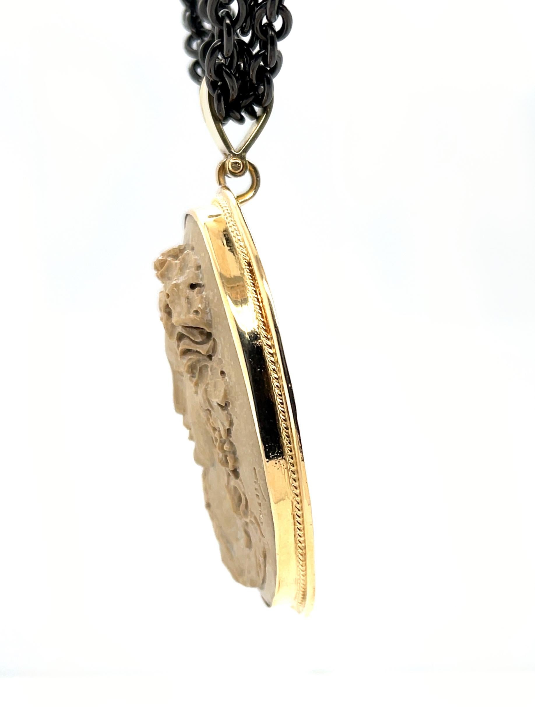 Este colgante tiene un hermoso camafeo tallado en un gran trozo de roca de lava italiana. El camafeo tiene detalles exquisitos que muestran una belleza intemporal.  Está engastado en un bisel de oro amarillo de 18 quilates hecho a mano. El colgante