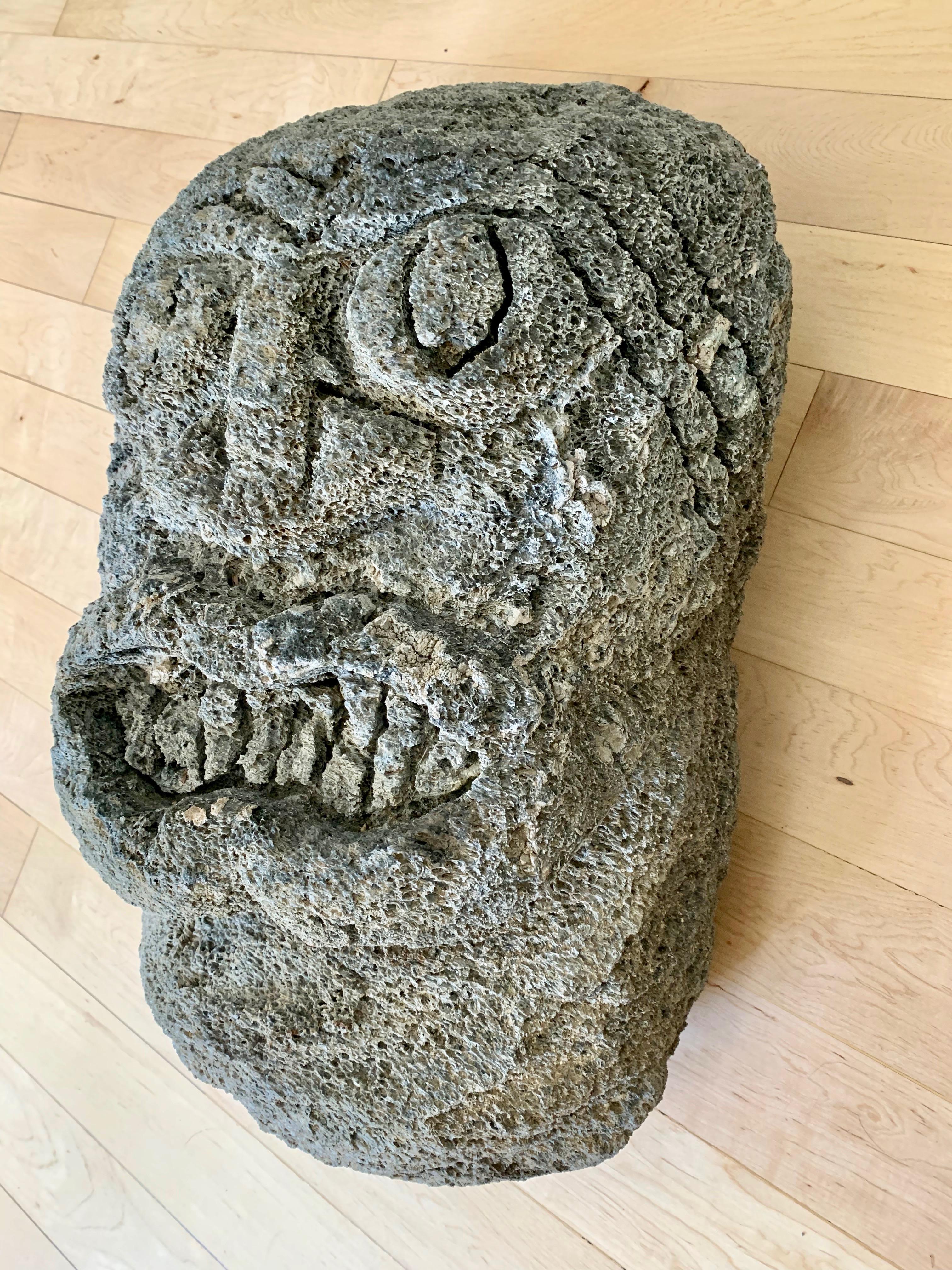 Heavy lava rock sculpture with a face hand carved into the front. Massive scale. Excellent condition. Huge presence and great coloring.