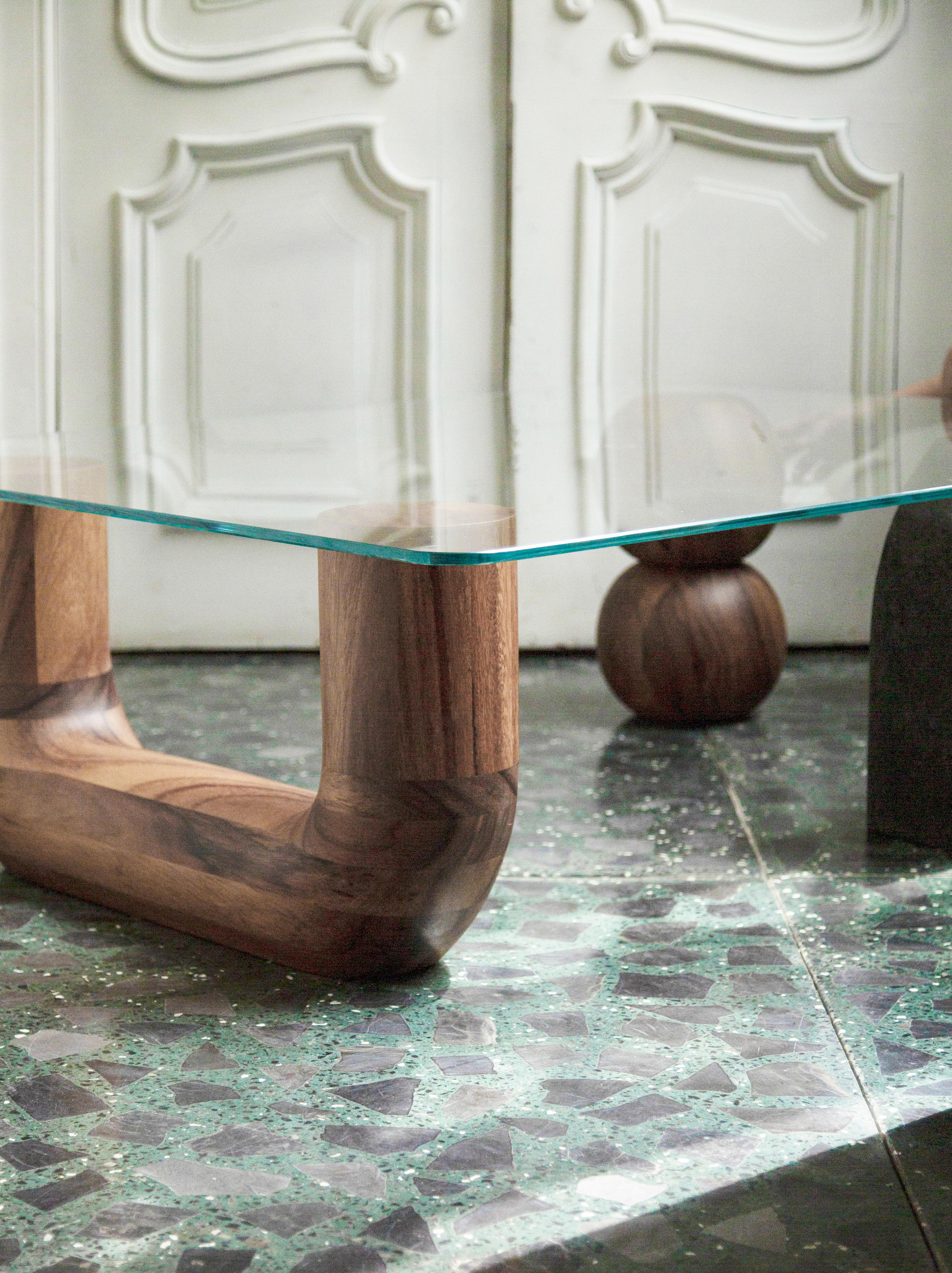 The Rosedal table is a sculptural coffee table assembled by three pieces. Two hand-shaped in Huanacaxtle solid wood and the other in volcanic stone; the top in glass lays down above, framing them.

We are Comité de Proyectos, an interior and